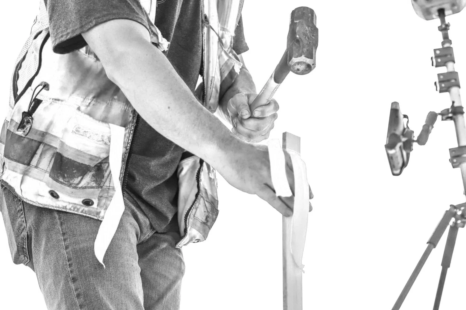 land surveyor pounding in marking stake