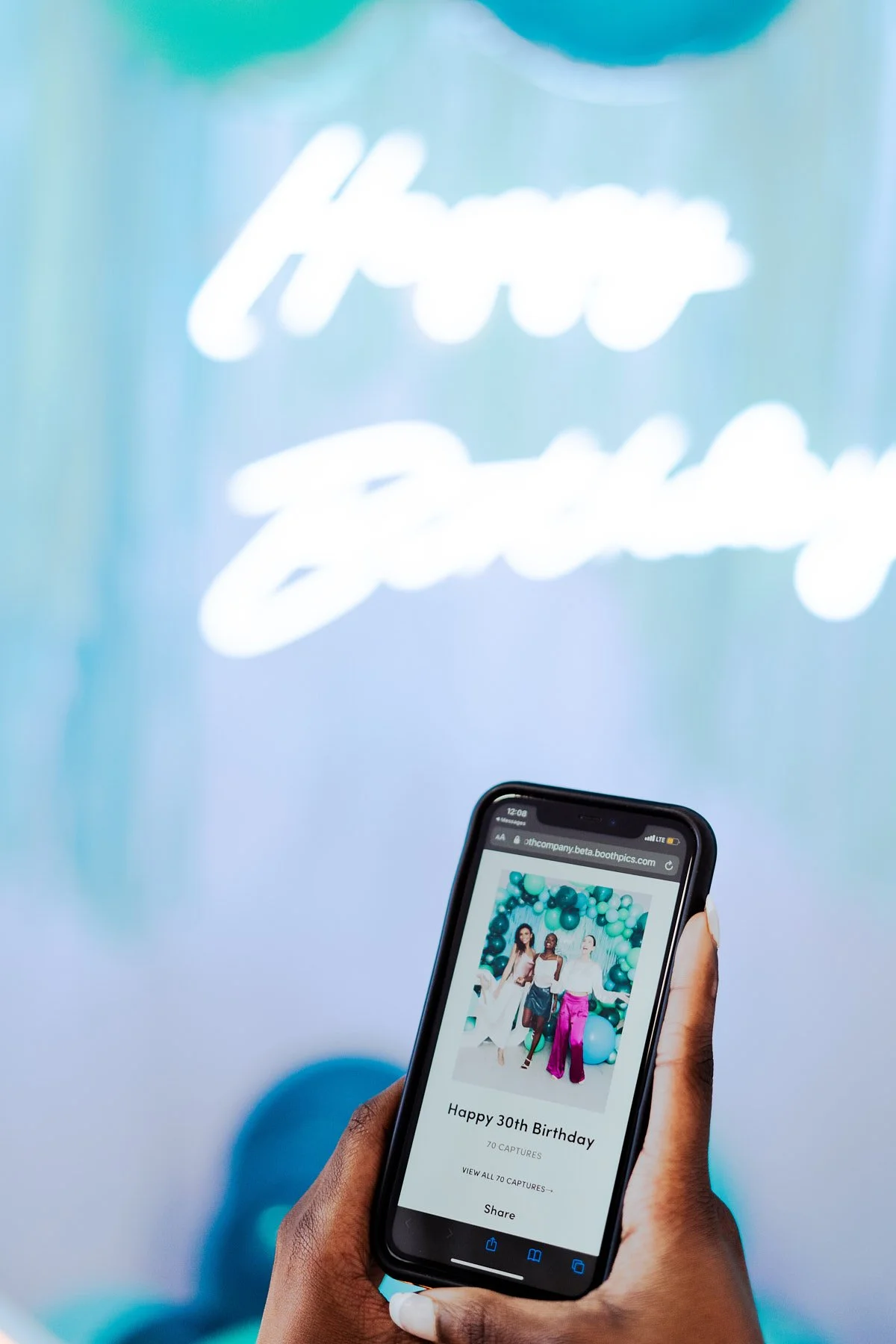 Guest sharing digital birthday photos instantly via a modern photo booth interface in a Seattle studio.