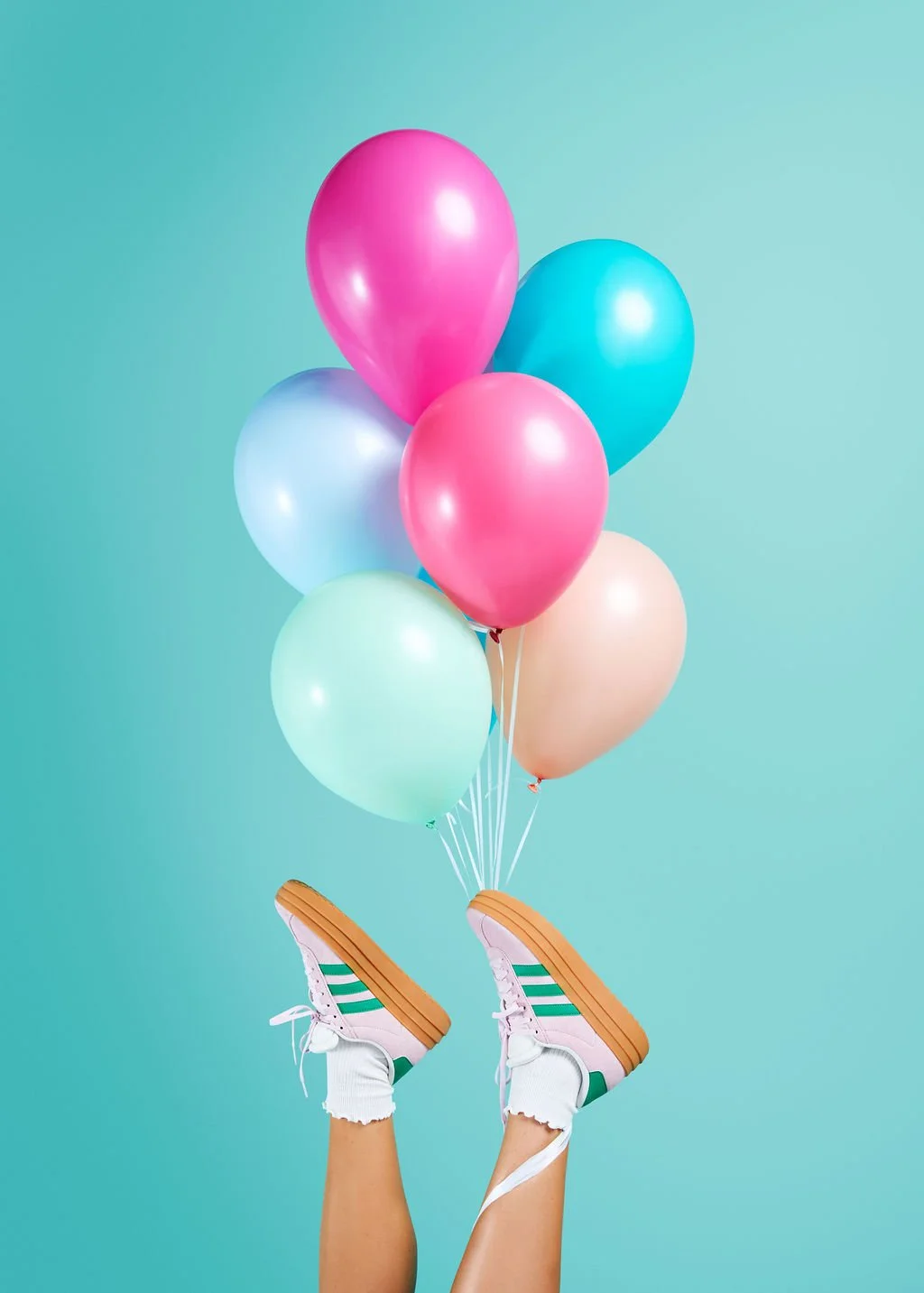 Creative birthday party supplies featuring a pastel balloon bundle tied to pink sneakers, perfect for unique celebrations and milestones in Madrona and Leschi.