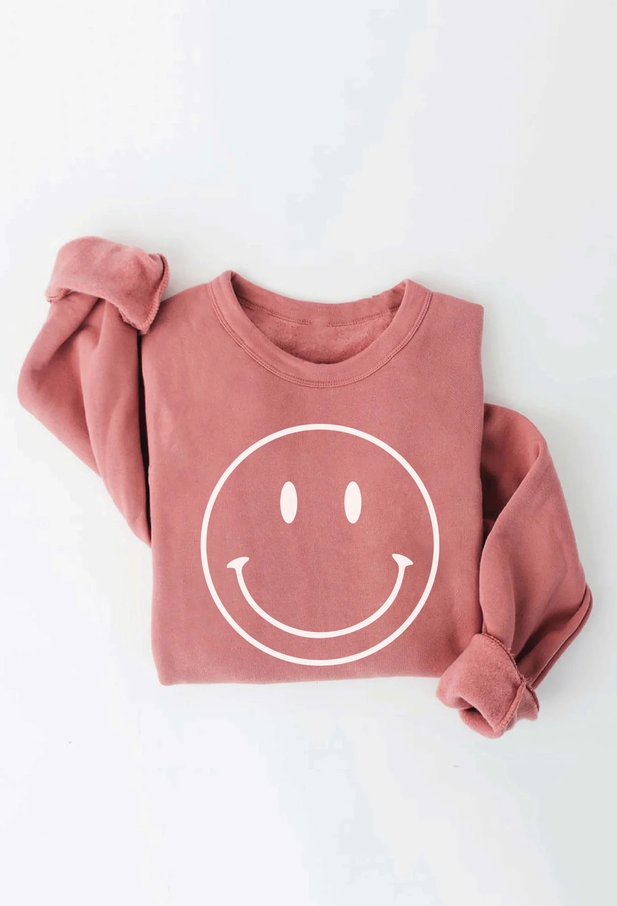 A mauve-colored sweatshirt featuring a white smiley face, offering cozy and intentional birthday party supplies for neighbors in Leschi and the Central District.