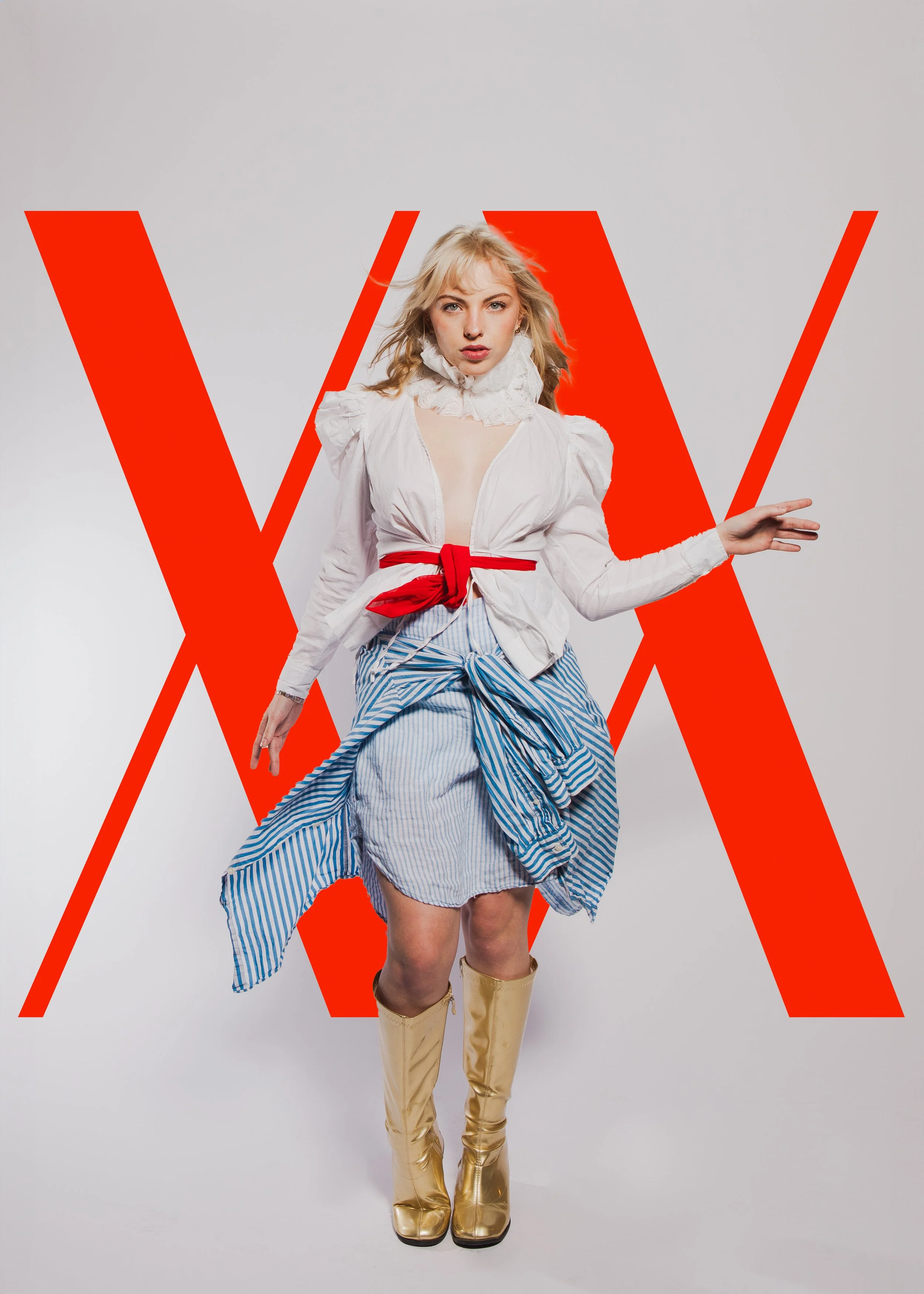 A woman with blonde hair wearing a white blouse with ruffled collar, striped skirt, and gold boots, standing in front of a white background with large red letters.