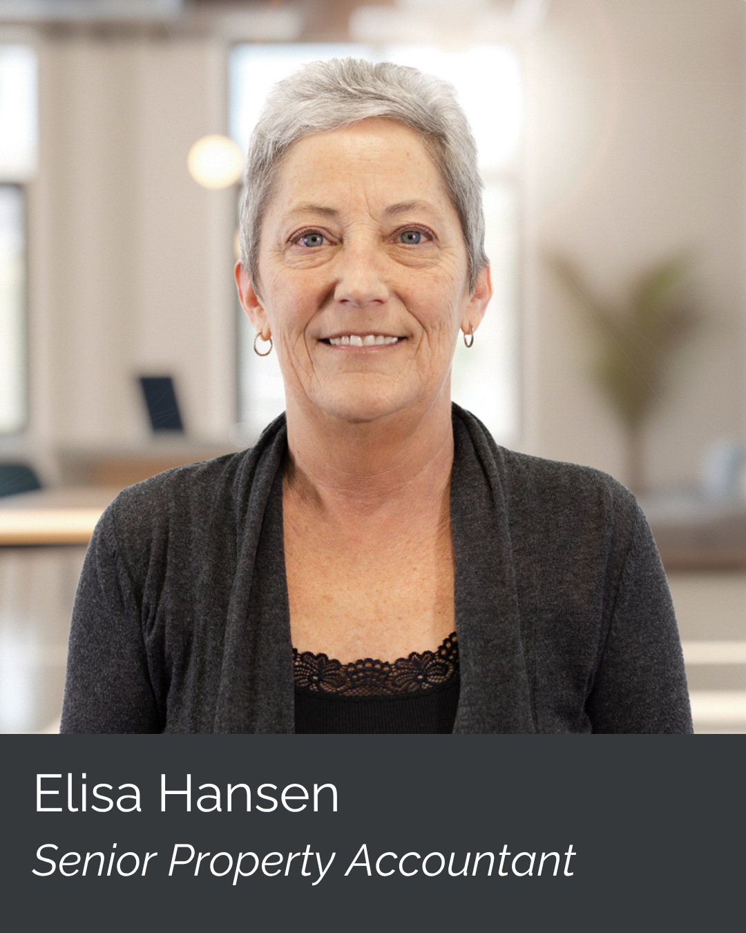 Portrait of Elisa Hansen, a senior property accountant, smiling in an office environment with blurred background.