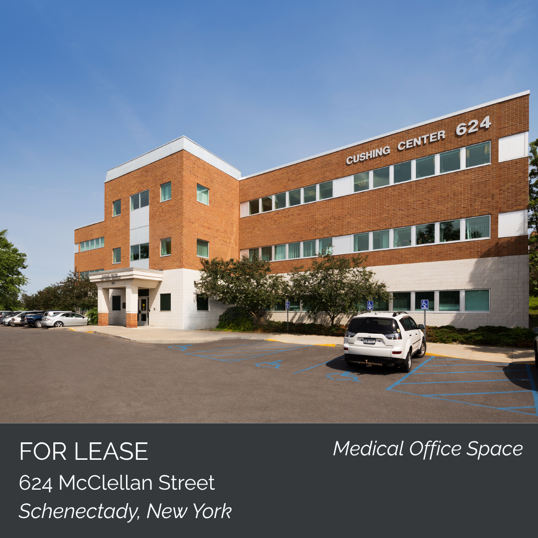 Exterior view of Cushing Center, a multi-story brick building with white accents and parking lot, located at 624 McClellan Street, Schenectady, New York, offering medical office space for lease.