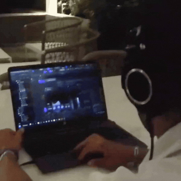 Aaron Tapia usando auriculares y produciendo una canción en una computadora portátil.