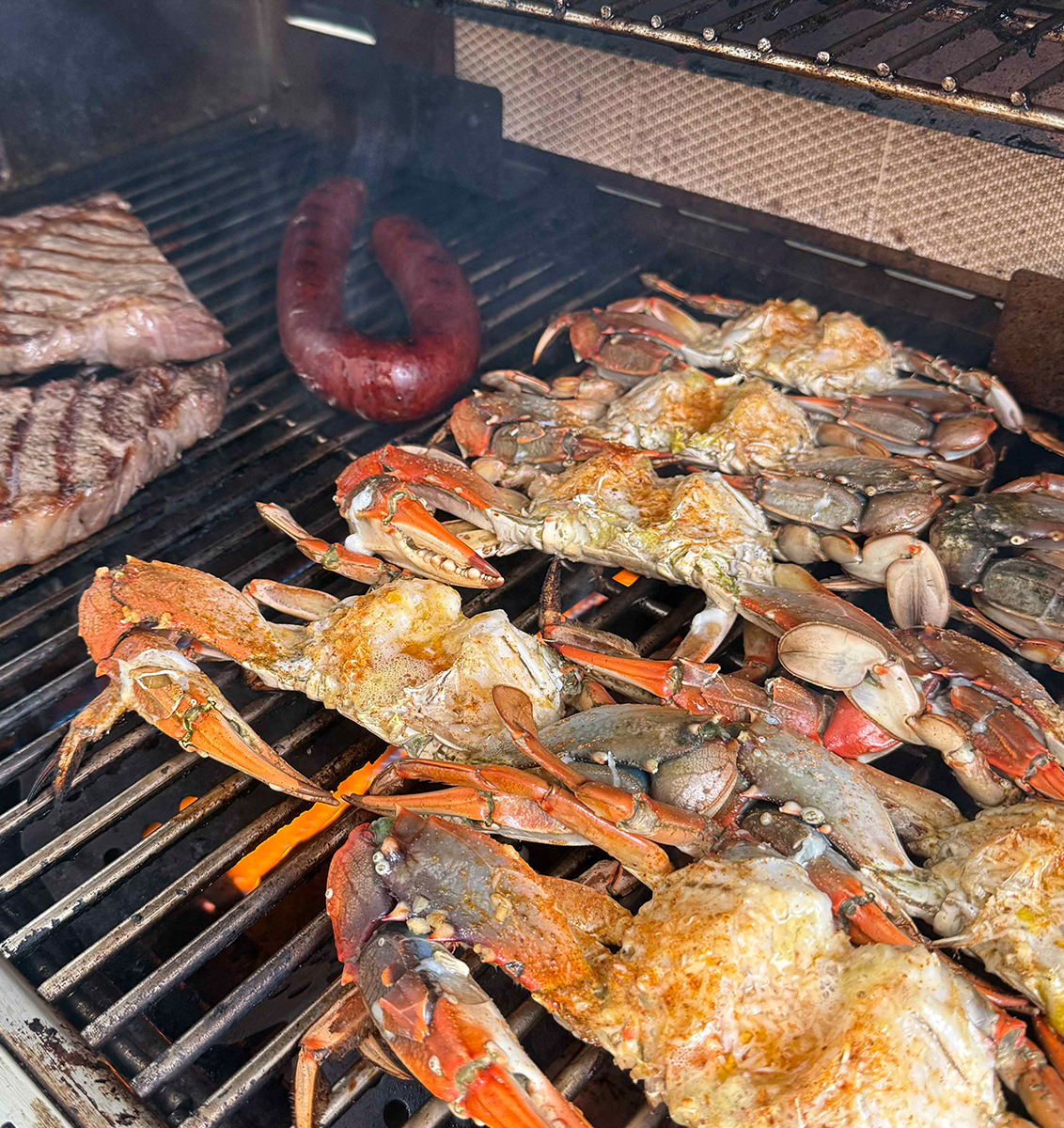 Steak, Blue Crabs, and Sausage on the grill