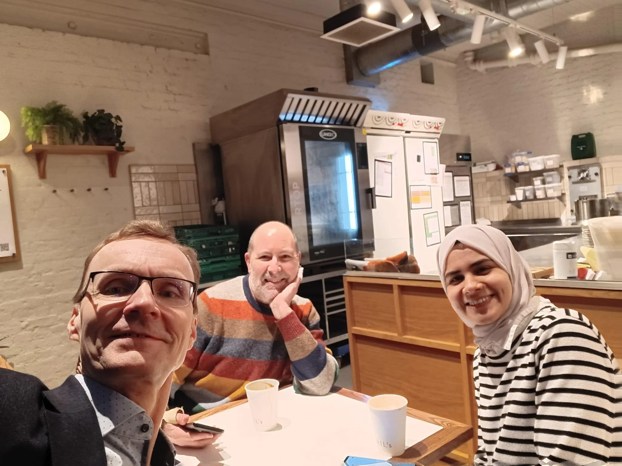 Jussi, Julian, and Rahaf meeting in a coffee shop