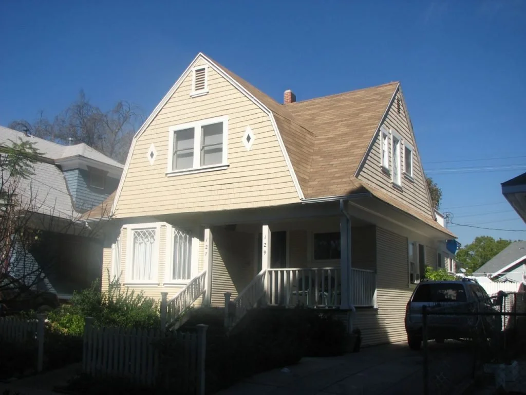 This Dutch Colonial at 127-129 Roselawn Place was returned to its former dignity by removing inappropriate stucco and replacing the original windows. The redwood siding was able to be saved but the upper shingles had to be replaced. The only thing th