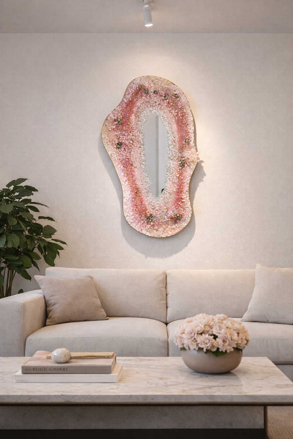Rose quartz asymmetrical geode mirror wall sculpture styled in modern luxury living room