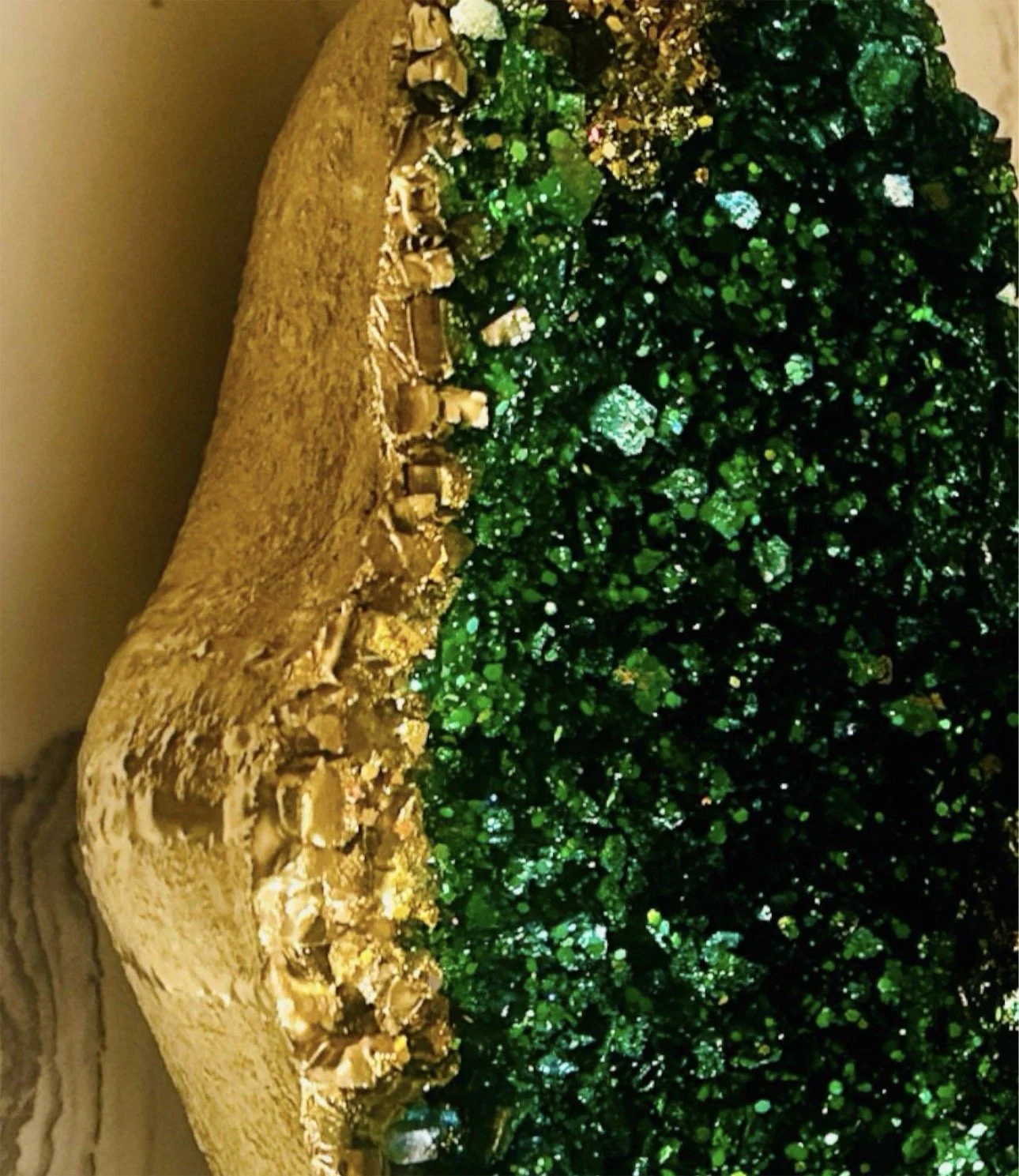 Close up of emerald malachite geode crystals with gold leaf mineral texture sculpture