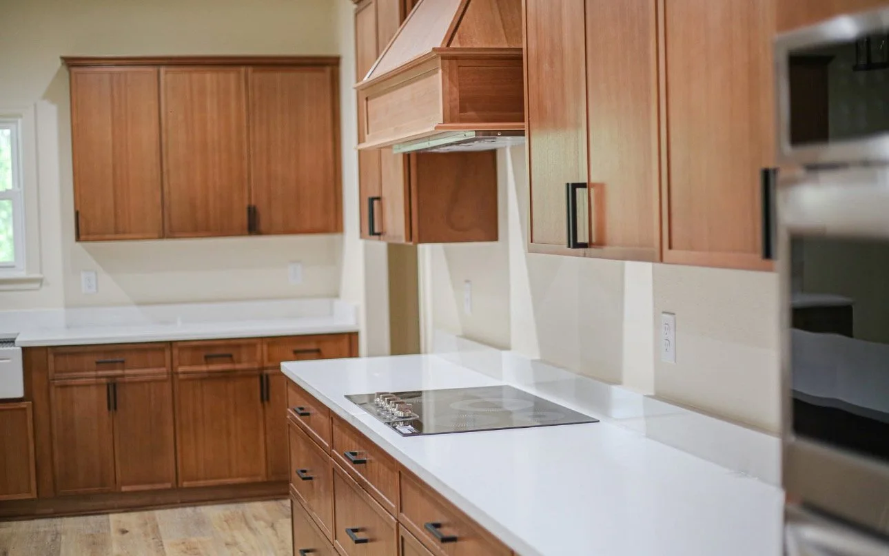 Kitchen with wooden cabinets, white countertops, and a built-in stovetop.