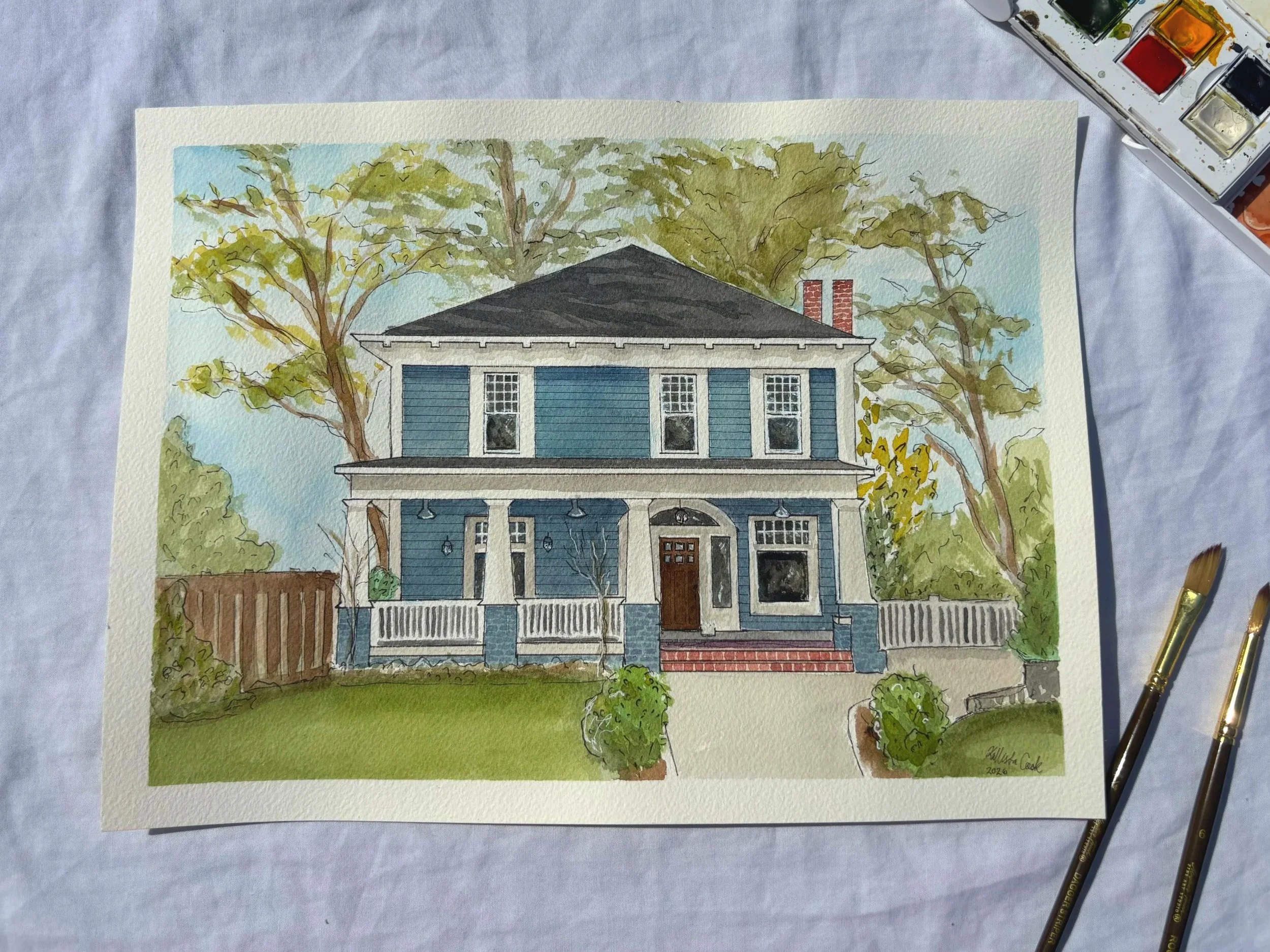 A watercolor painting of a two-story blue house with white trim, a front porch with columns, surrounded by greenery and trees, with a clear sky background.