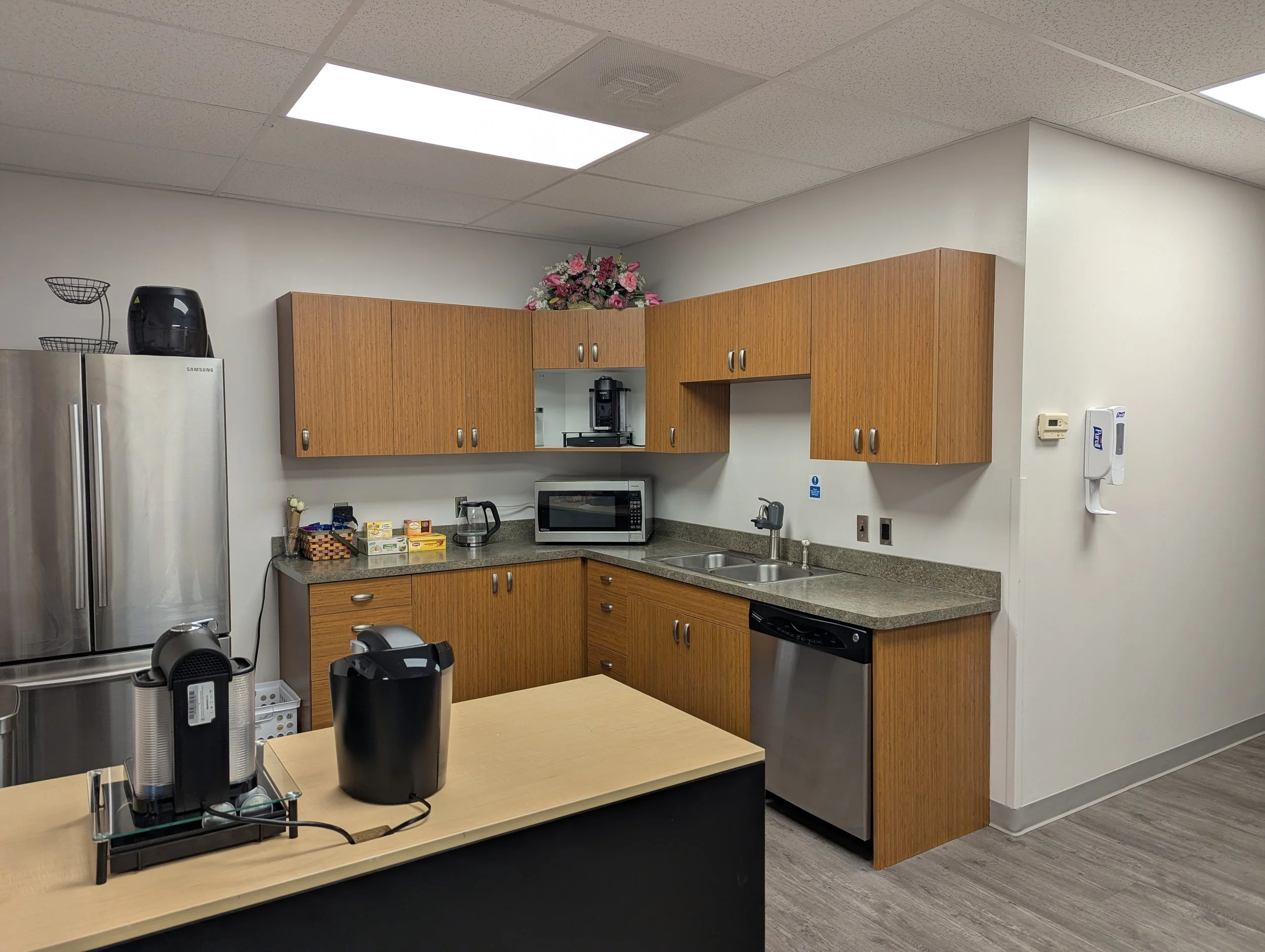 Noble Executive Suites & Offices has a kitchenette with a full-sized refrigerator, coffee makers, and seating.