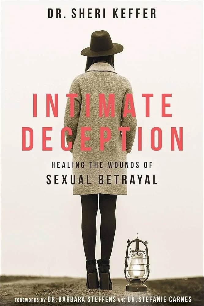 Book cover for 'Intimate Deception' by Dr. Sheri Keffer, featuring a woman in a coat, leggings, and boots, with a hat, viewed from behind and standing outdoors next to an old-fashioned lantern.