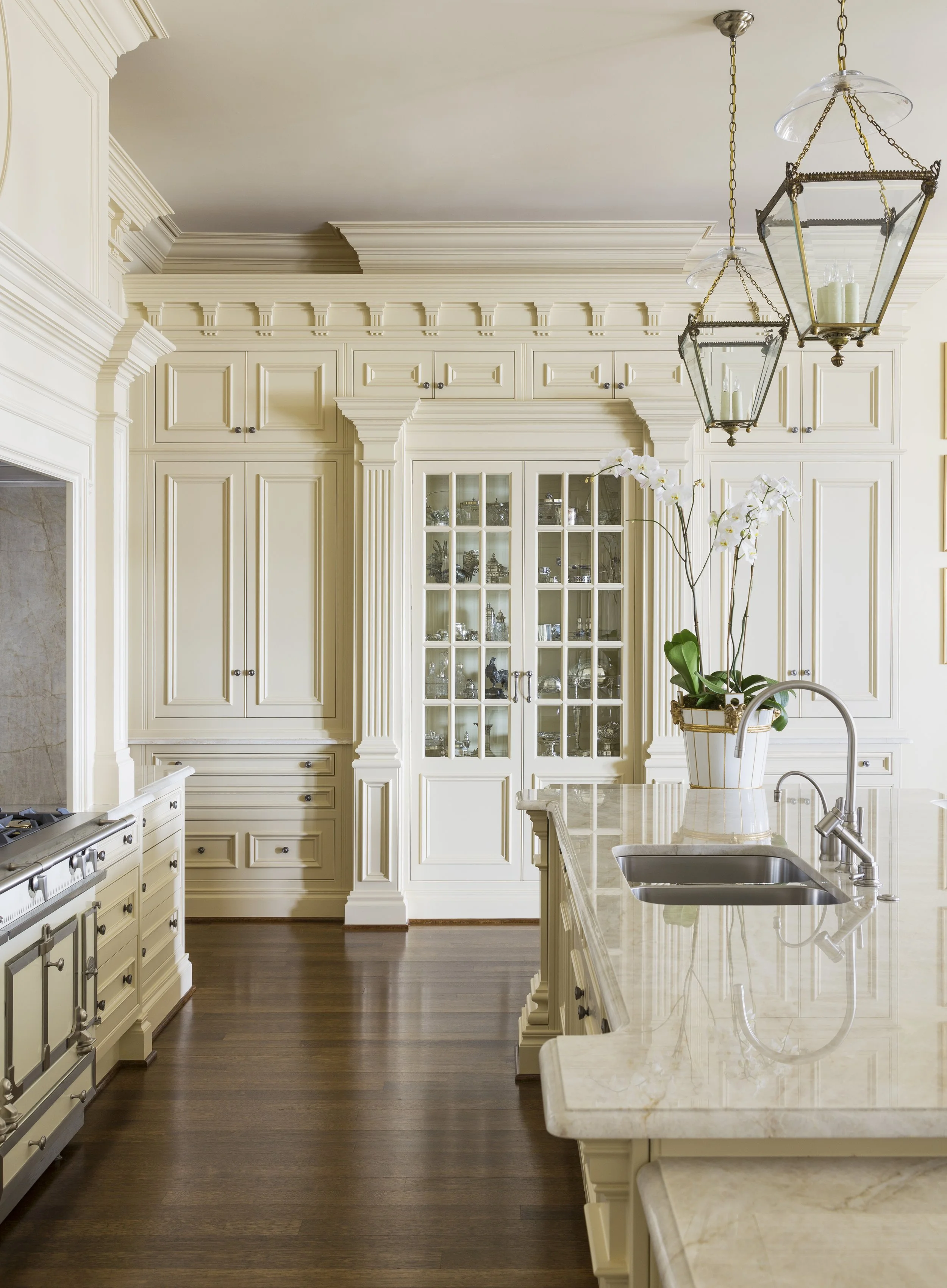 Clive Christian kitchen with cream cabinetry, beveled glass doors, and marble countertop island.