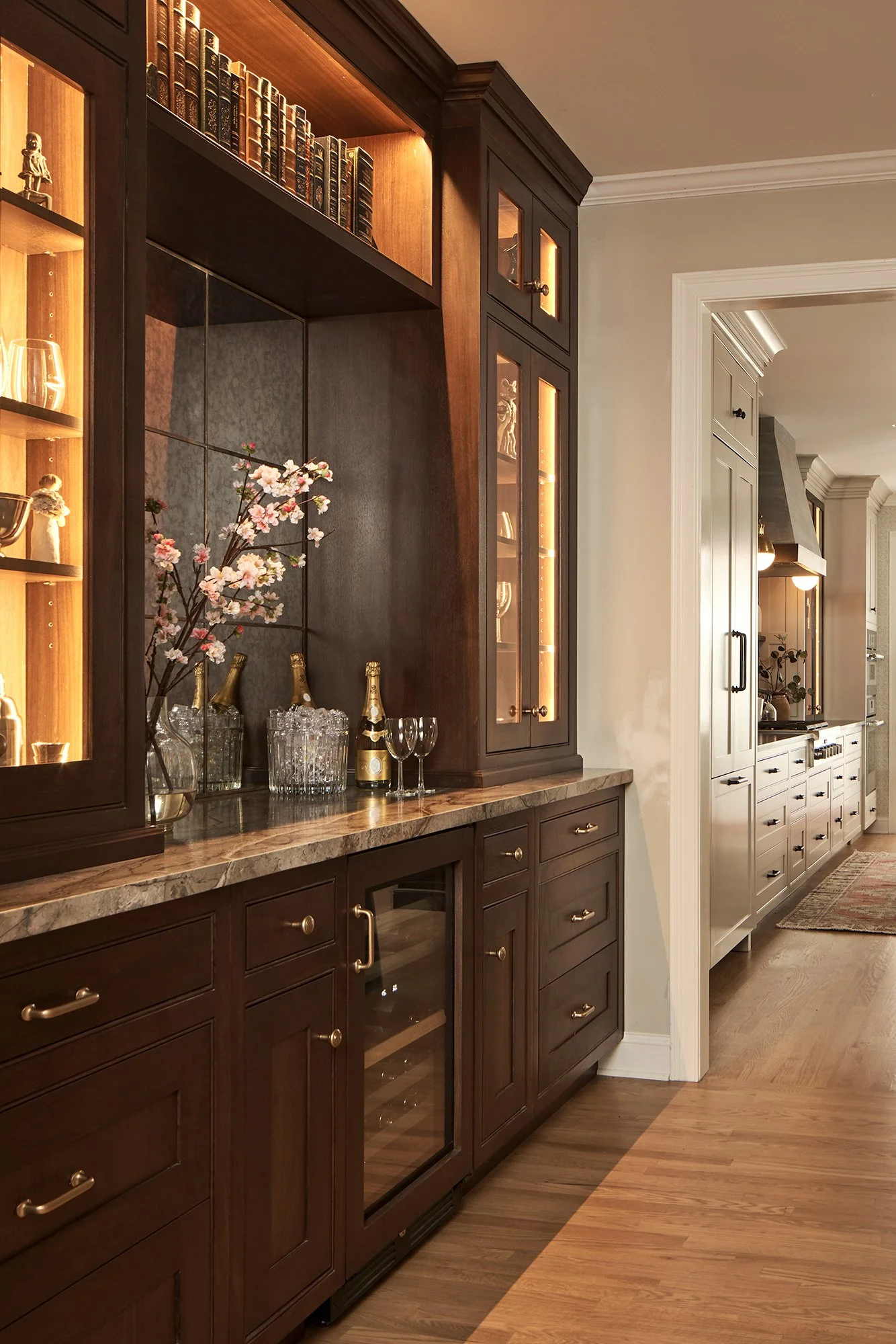 Built-in bar with walnut cabinetry, beveled glass display, and quartzite countertop.