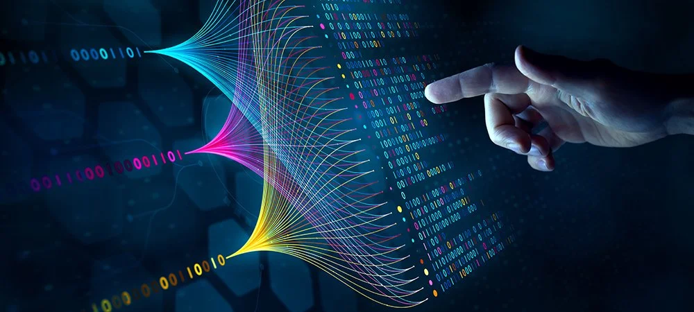 A person points at a digital display with colorful data flow and binary code, symbolizing data processing or artificial intelligence.