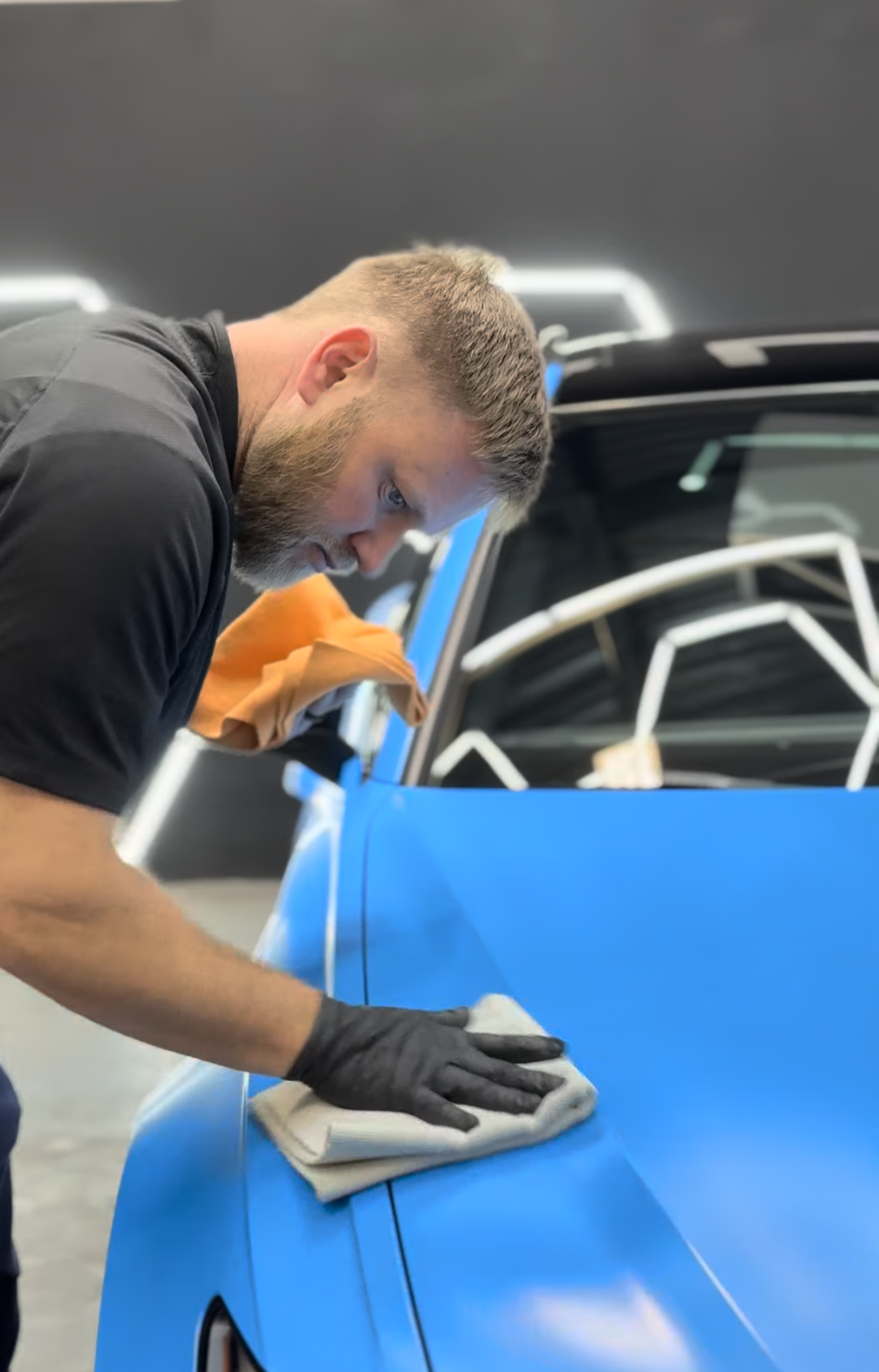 Technician applying ceramic coating to a premium vehicle at Zeal Restyling