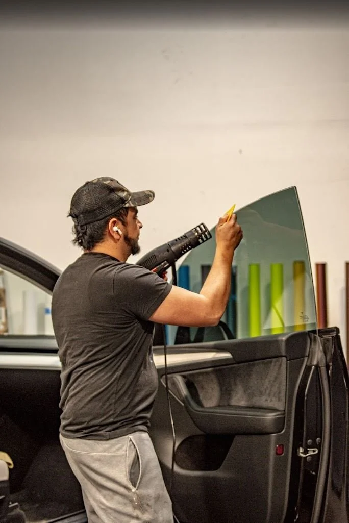 Lead technician applying premium ceramic tint film to a car window at Zeal Restyling