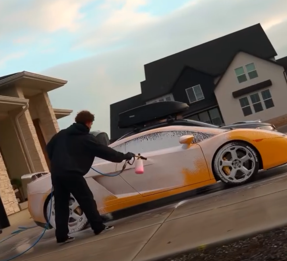 Technician washing a yellow Lamborghini during a mobile detailing appointment