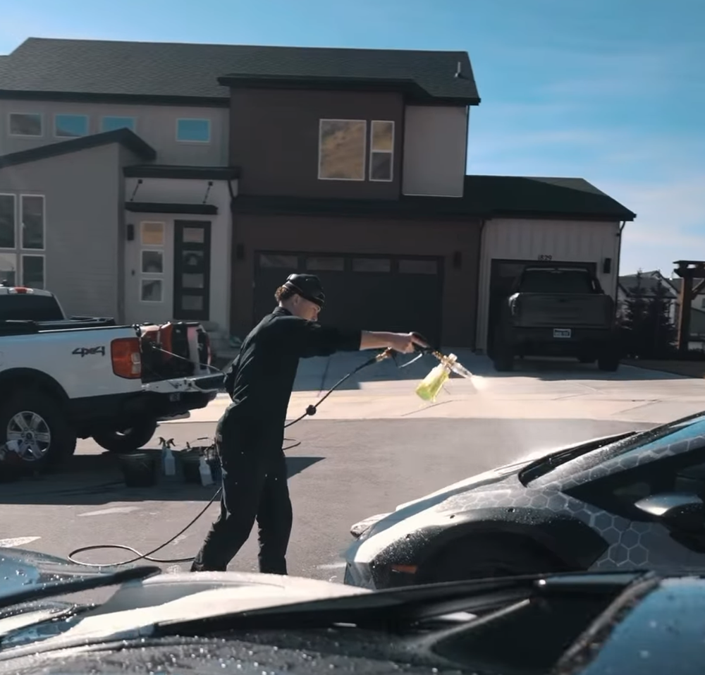 Technician detailing a Lamborghini on a driveway in Utah