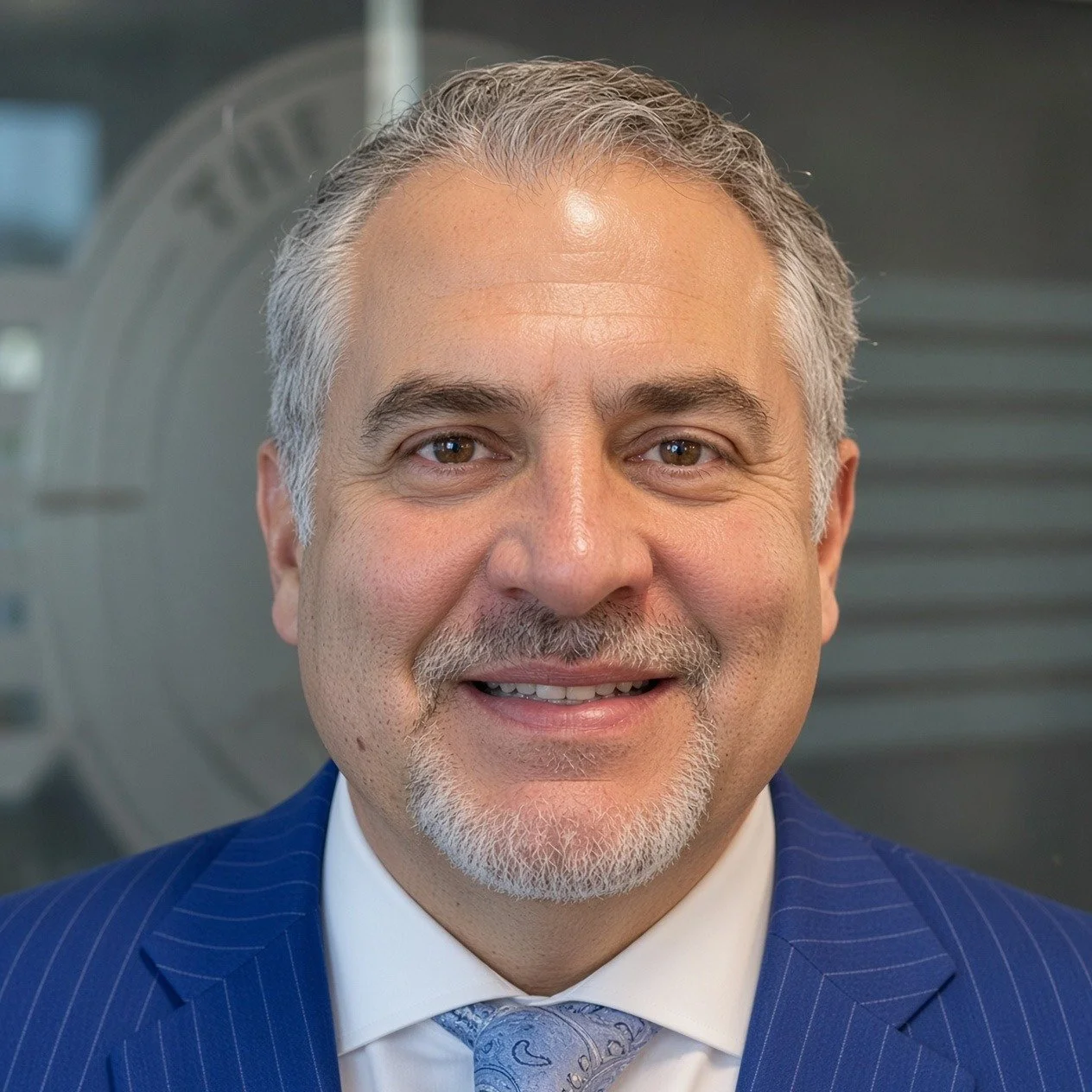 Headshot of Mac Pilgrim, lead attorney at The Pilgrim Law Group, smiling in a blue pinstripe suit