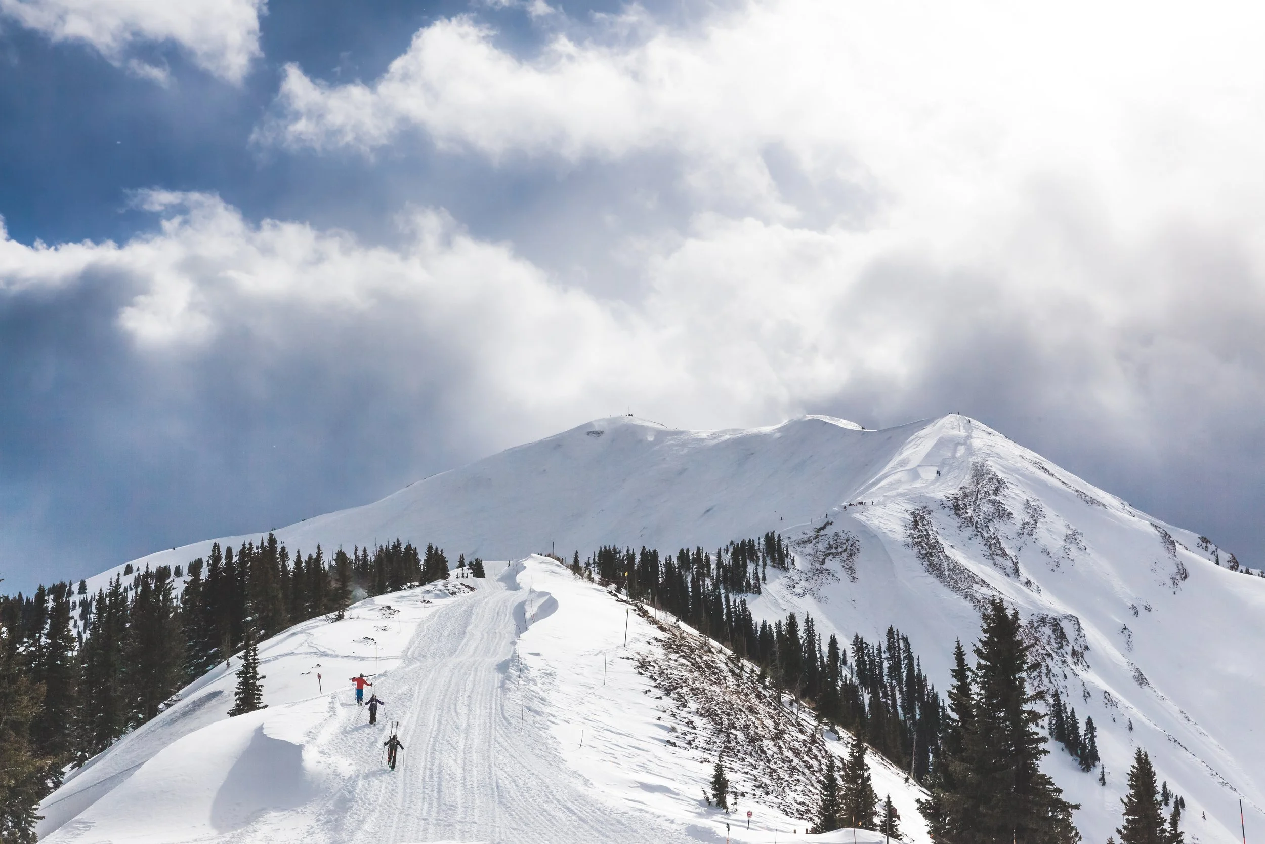 Skiers walking up a trail in Aspen, Colorado