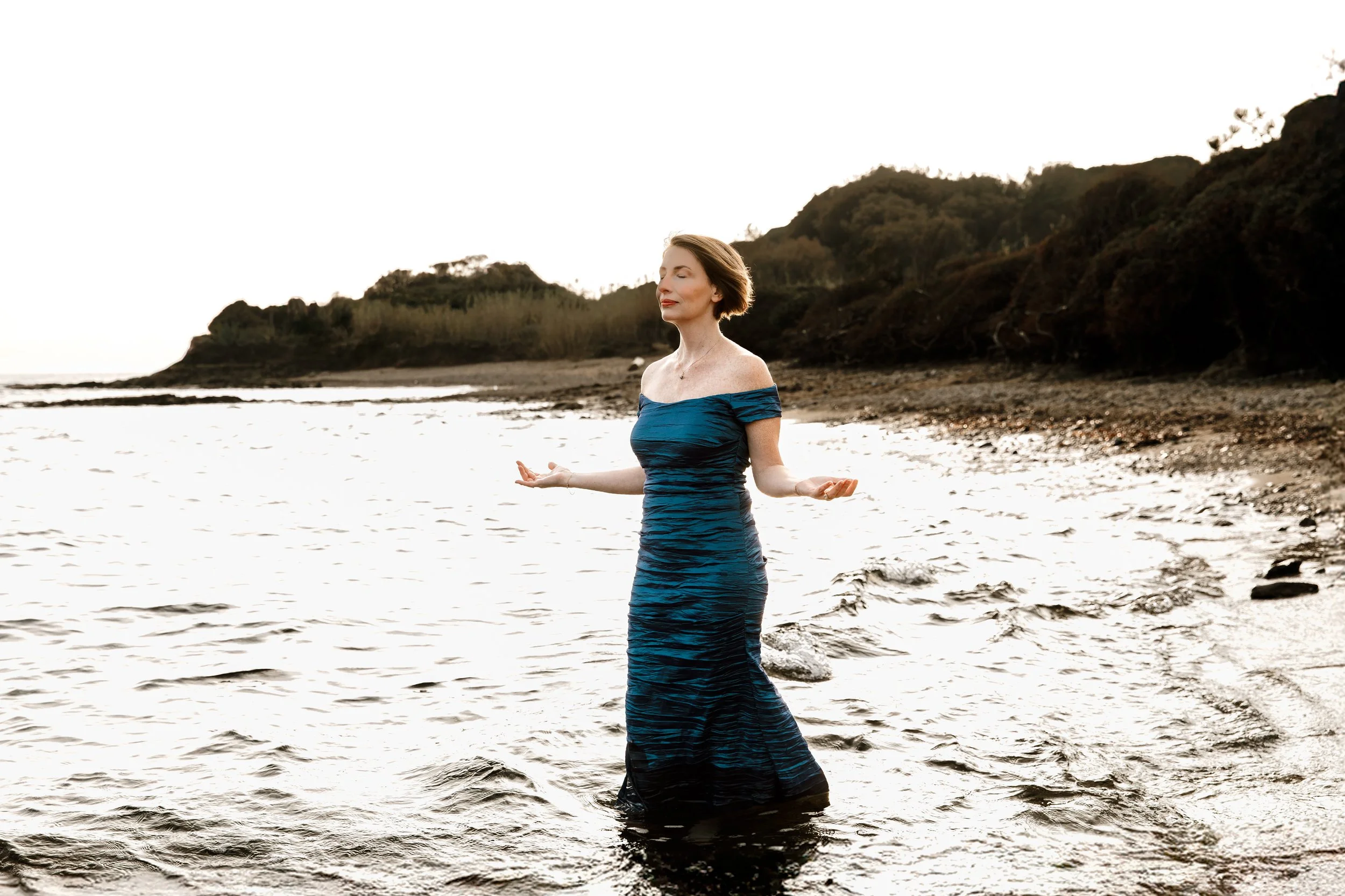 RaChel Benyair practicing meditation in the ocean at sunset.