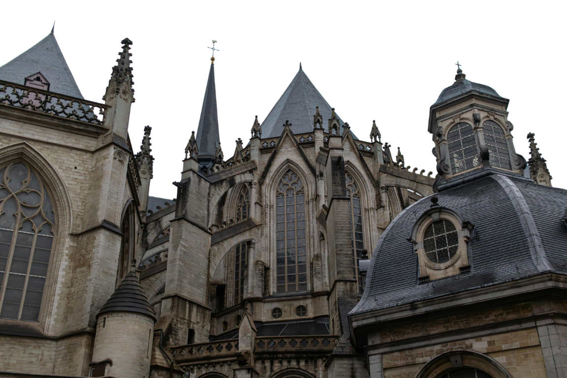 Close-up of a gothic cathedral with pointed arches, large stained glass windows, and intricate stone details on the spires and roof.
