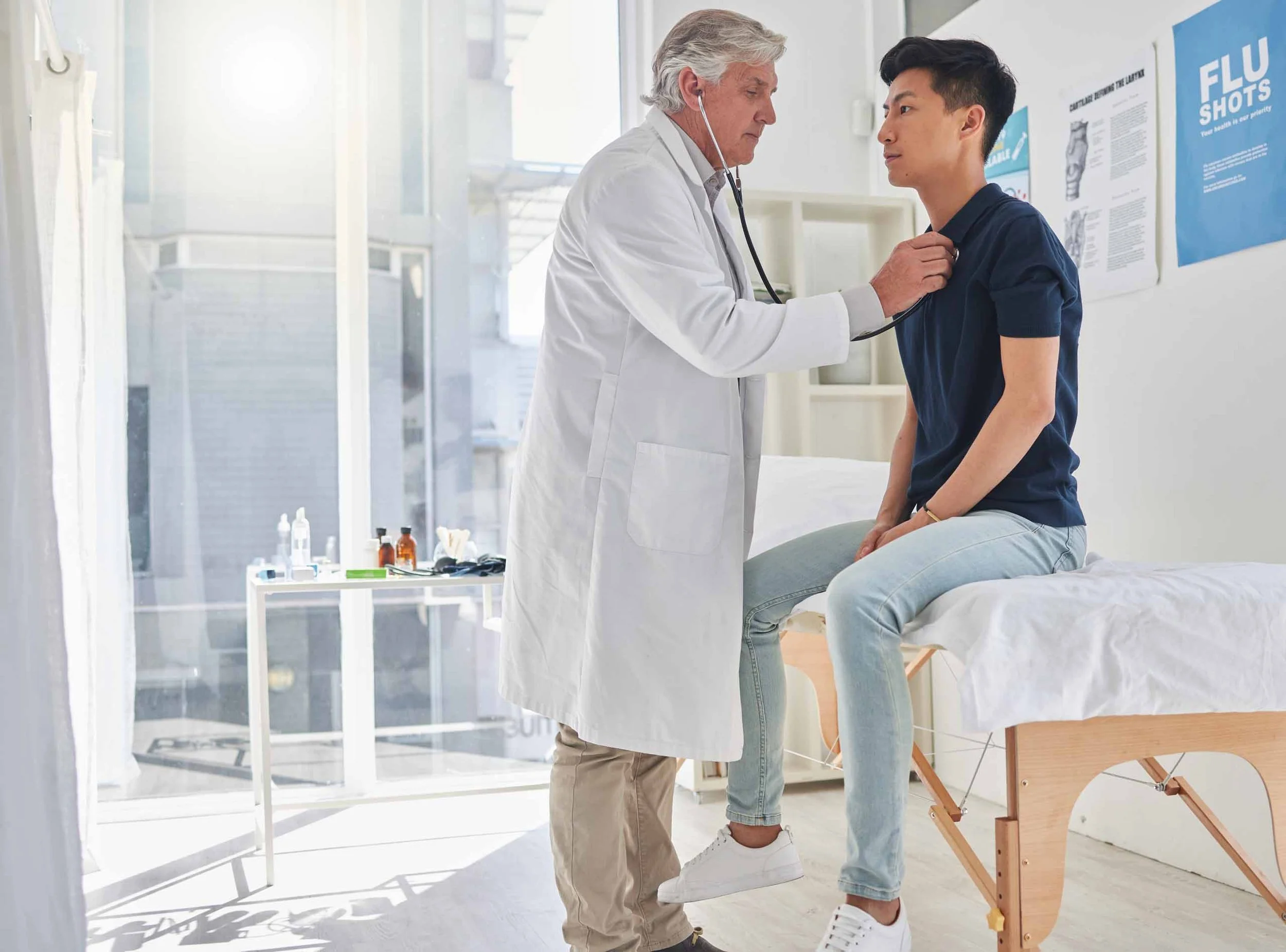 A doctor listening to a young male