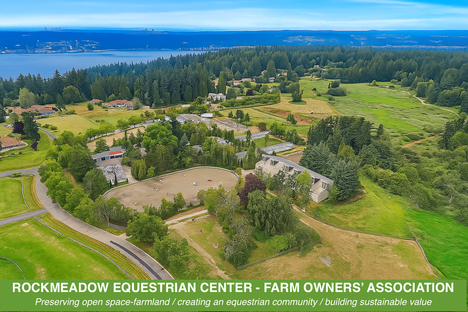 Aerial view of Rockmeadow Equestrian Center with open farmland, riding arenas, trees, and a distant body of water in the background.