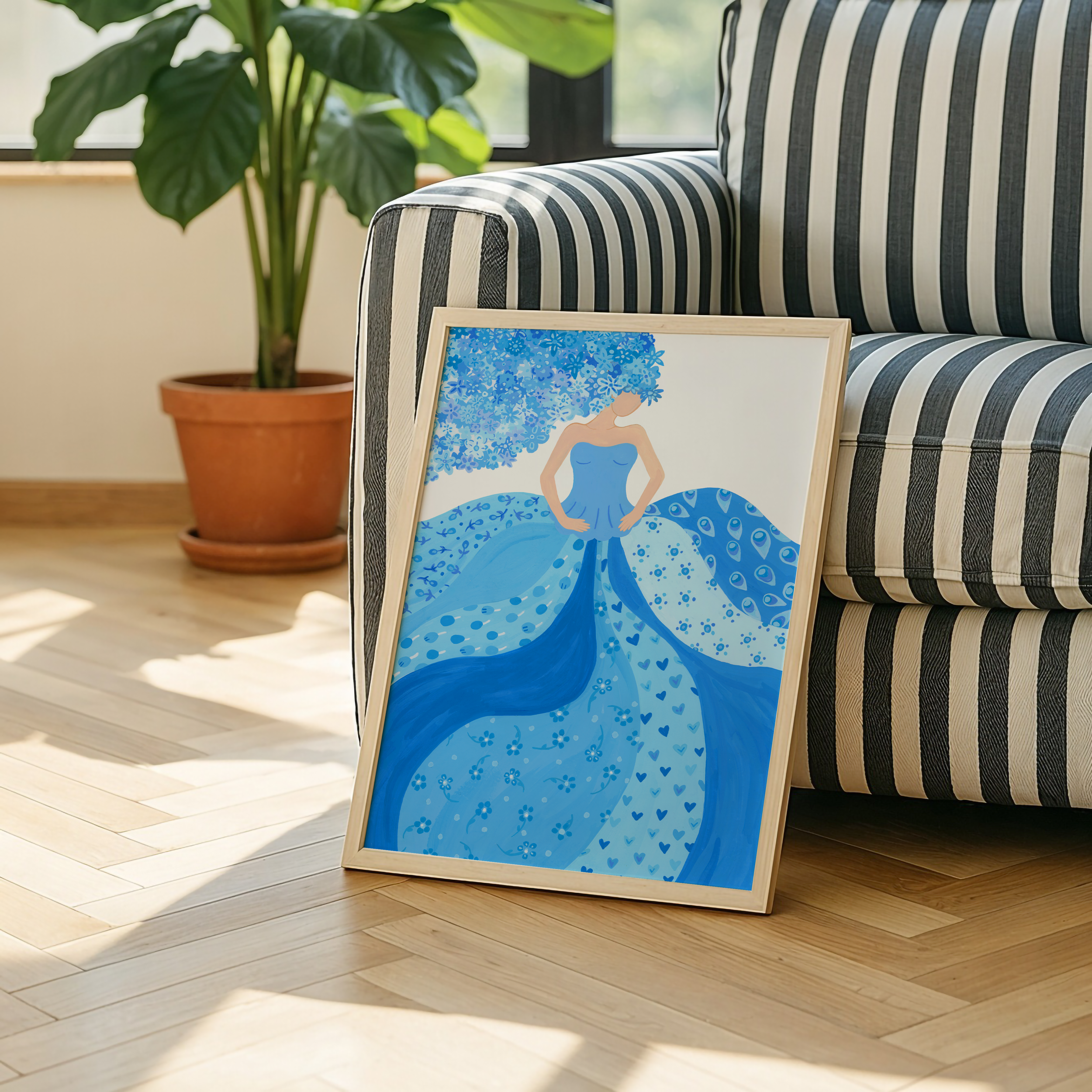 Art print of a woman in a blue dress placed against a couch