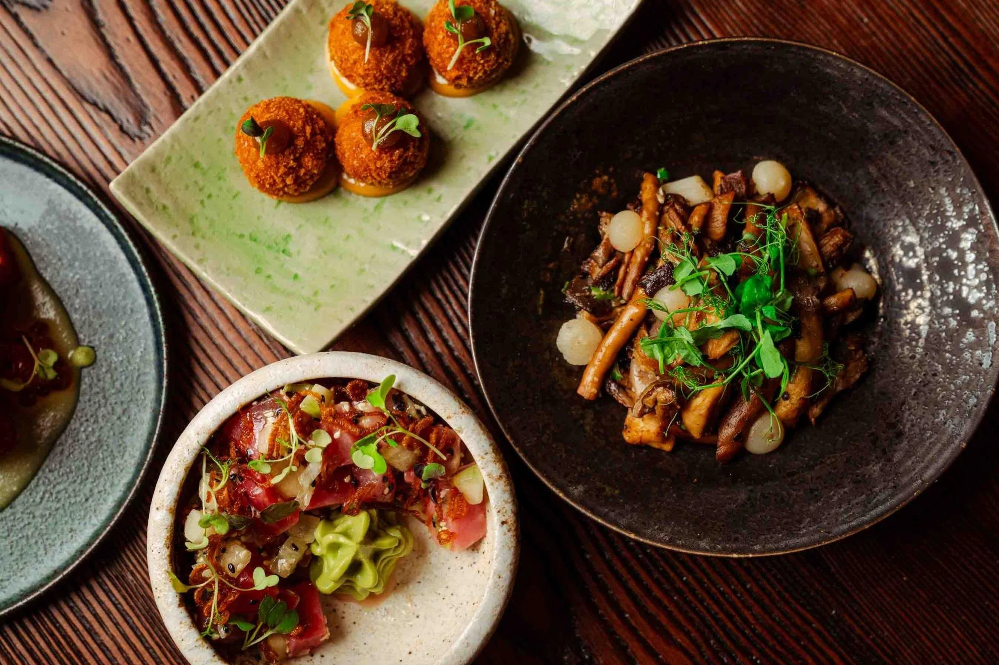 Overhead spread of small plates: croquettes, sauteed mushrooms and tuna poke at Spork Island Trading Company, a new restaurant in downtown Pittsburgh