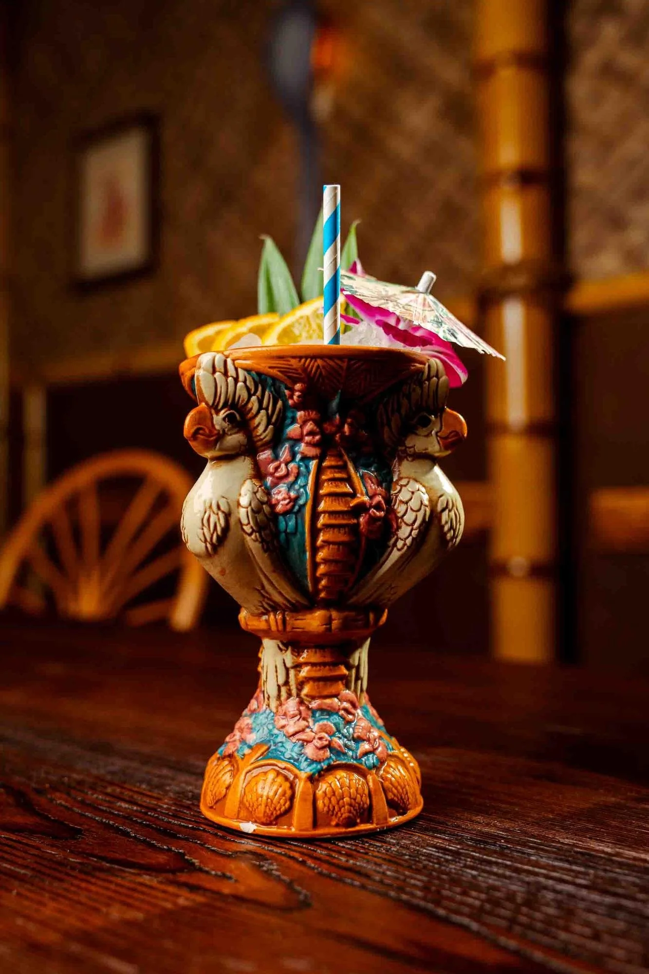 Sporky Sling cocktail in a twin-parrot tiki goblet with crushed ice and orange wheels at Spork Island Trading Company, a Pittsburgh tiki bar