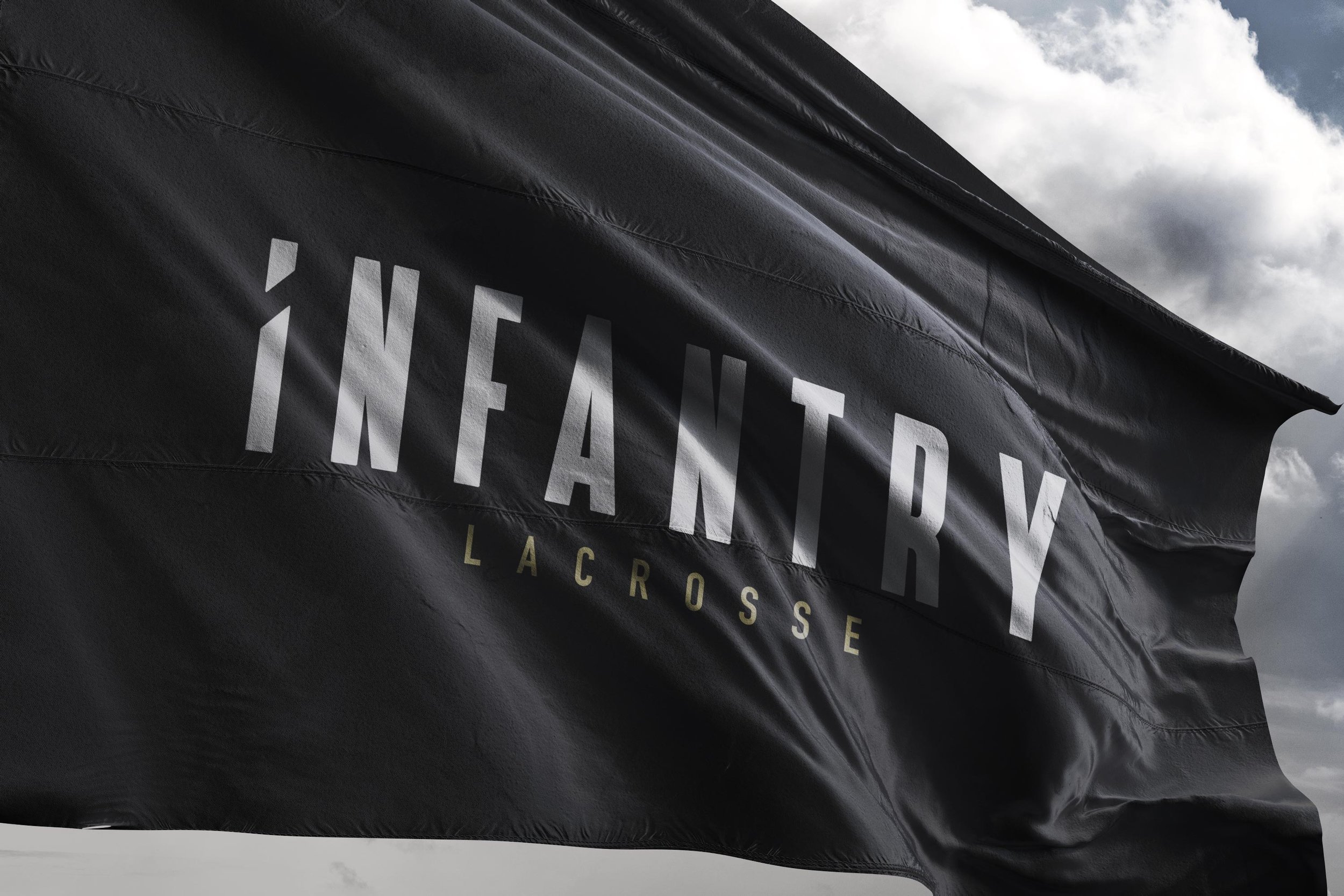 Black flag with "Infantry Lacrosse" logo against a cloudy sky.