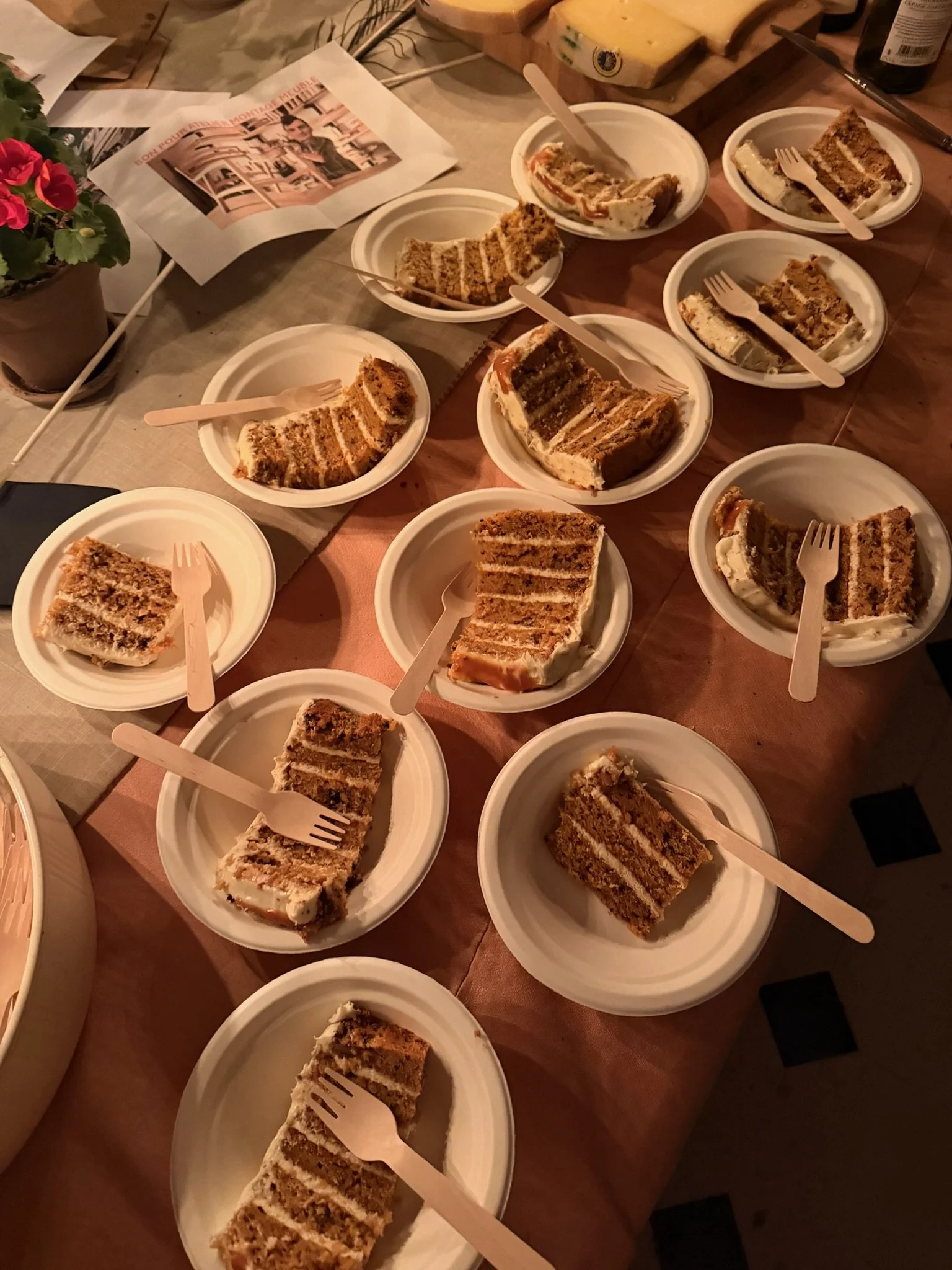 Multiple plates with slices of layered carrot cake at a gathering or party.