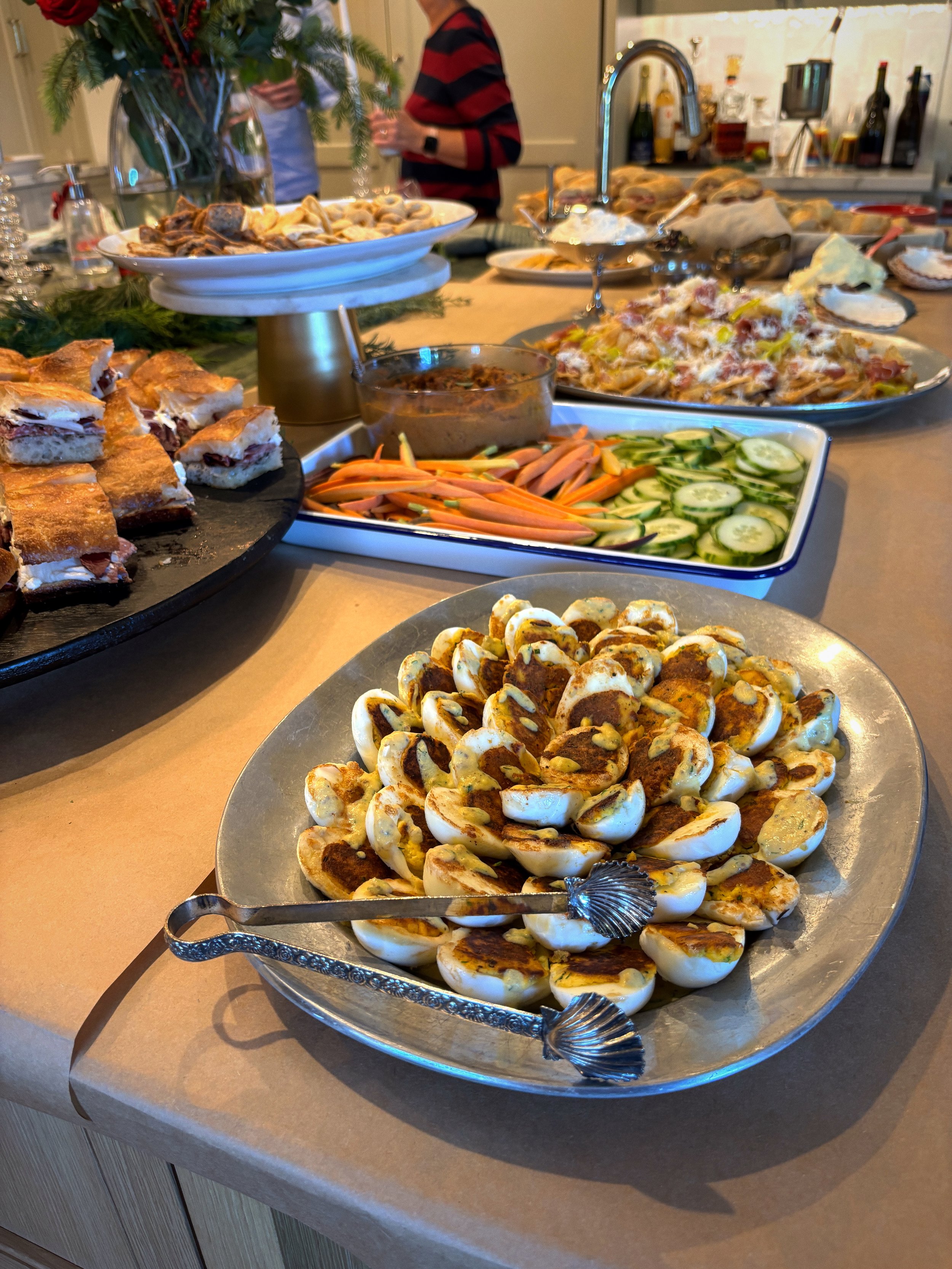 Plate of sliced hard-boiled eggs topped with paprika or chili powder, served with tongs.