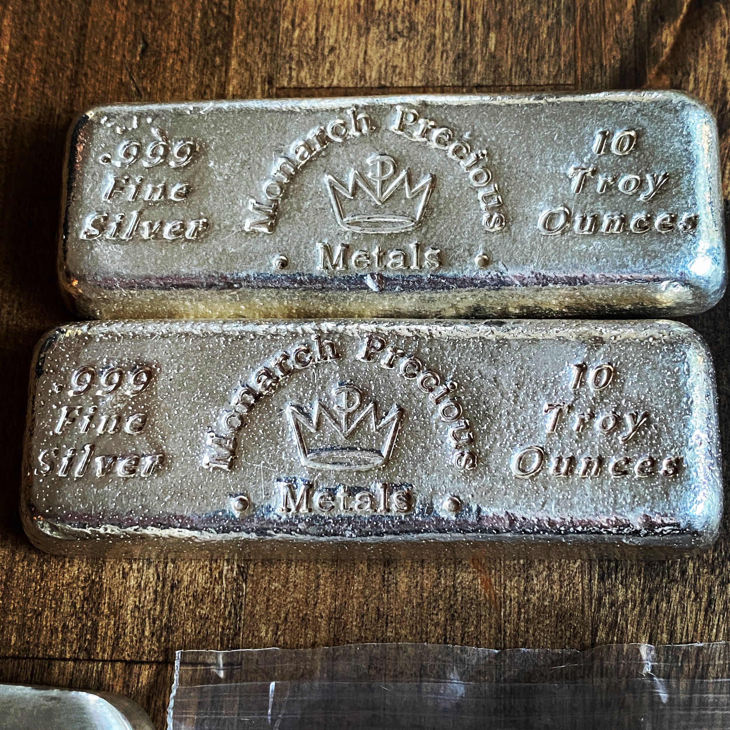 Two silver bars, each marked with '999 Fine Silver' and '10 Troy Ounces,' featuring a crown logo and the words 'International Packard Packets Metals.'