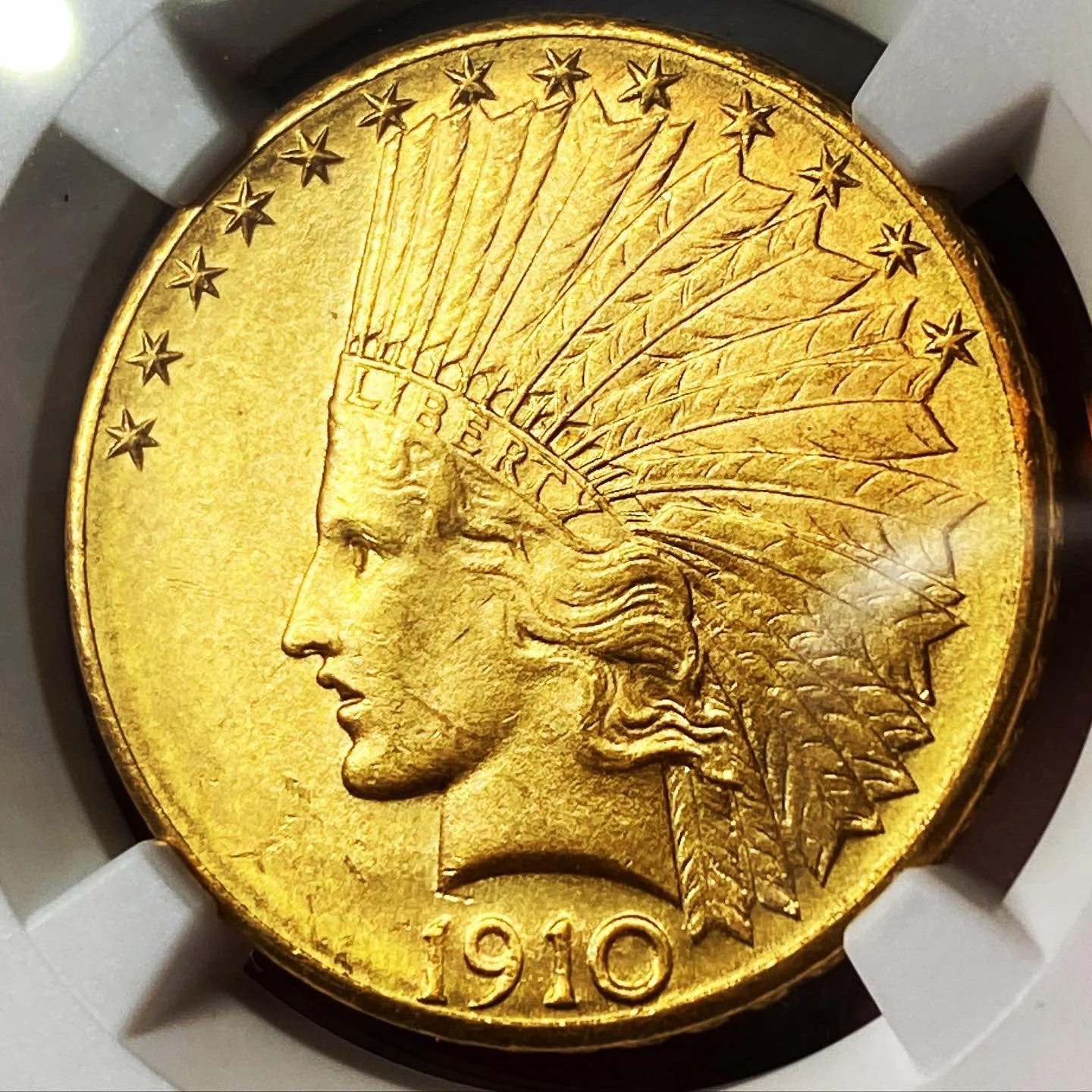 A 1910 American gold coin featuring a Native American chief in a headdress on the obverse side.