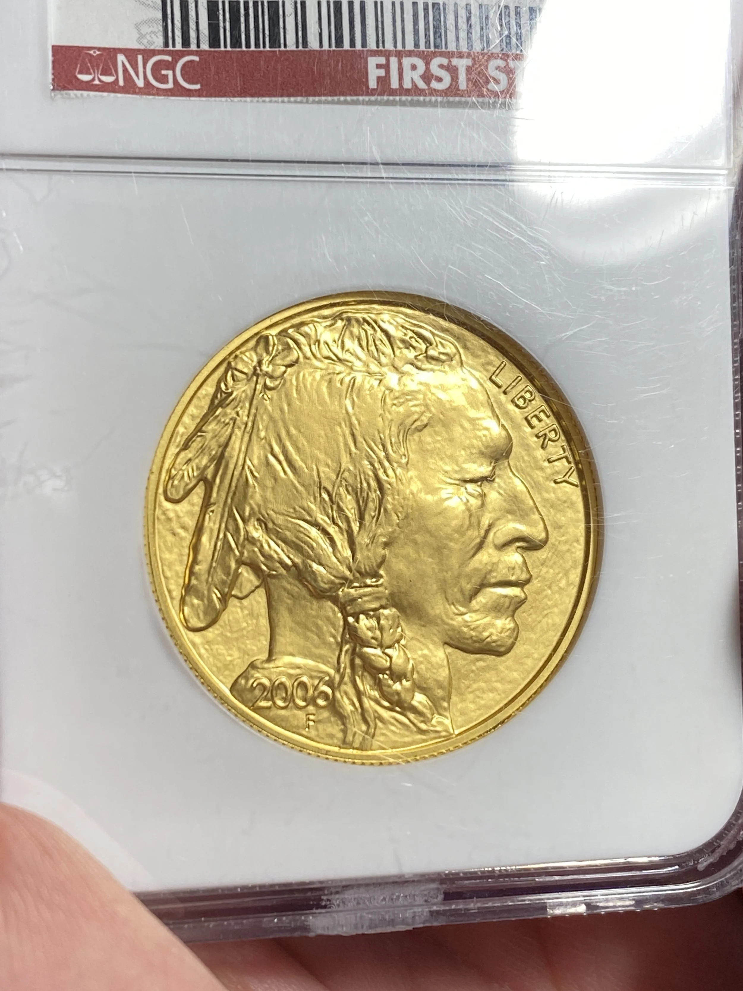 A 2006 American gold coin, depicting a Native American in profile with the word 'LIBERTY' to the right. The coin is in a protective plastic case with a label indicating it is graded by NGC.