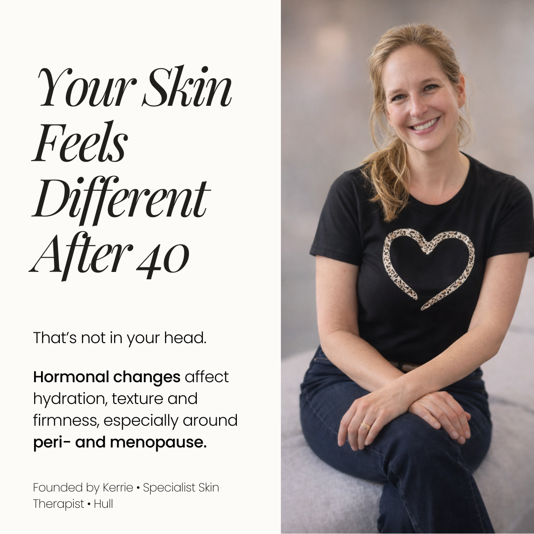 A smiling woman sitting cross-legged on the floor wearing a black T-shirt with a leopard print heart design.