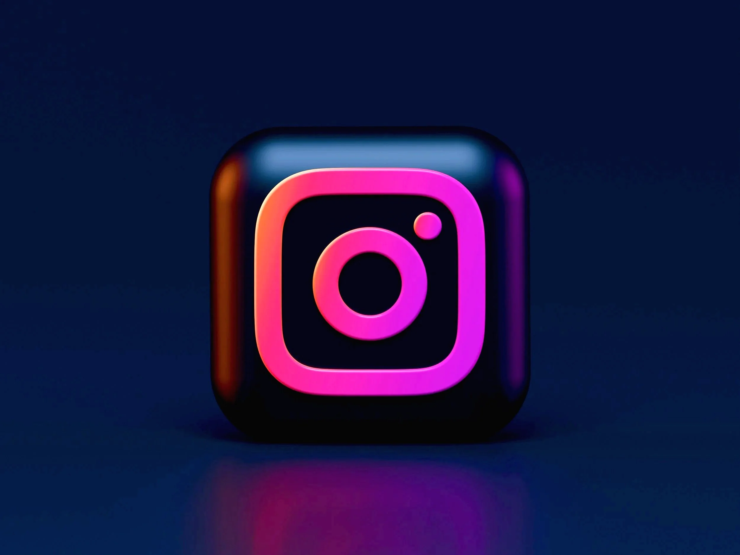 A glowing neon Instagram logo on a dark background.
