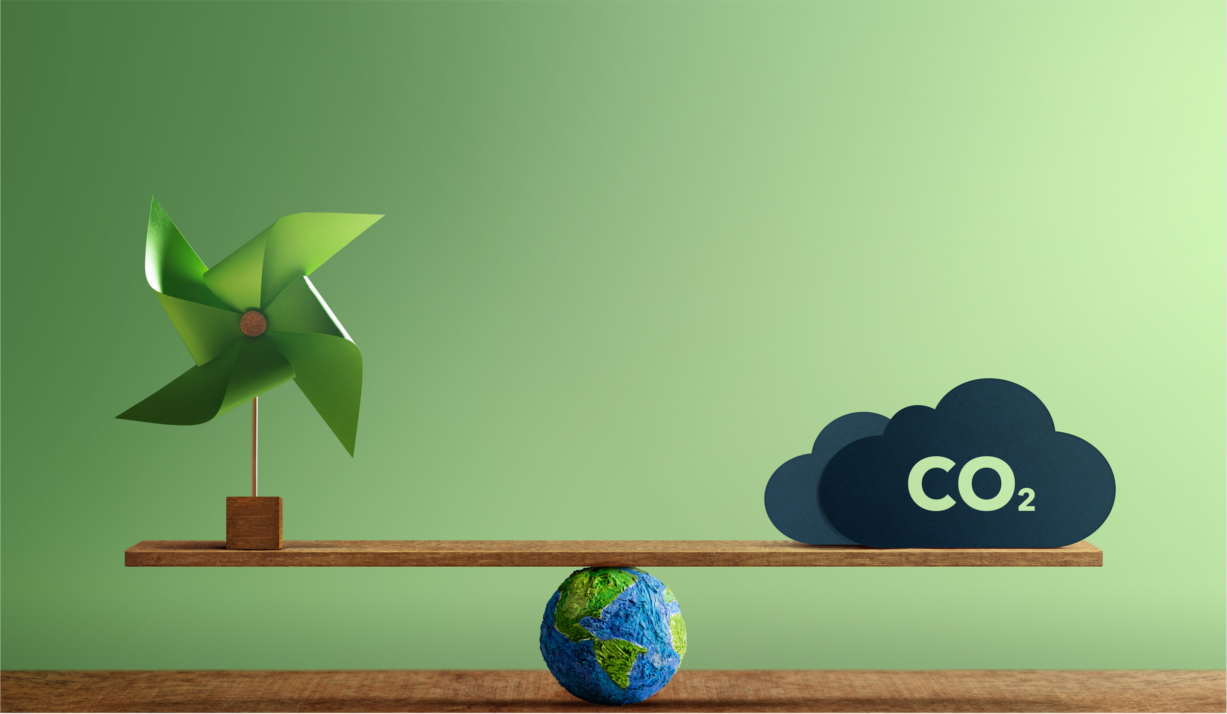 Un diagrama con una turbina de viento, un planeta Tierra y una nube con la fórmula CO₂, simbolizando energías limpias y reducción de emisiones de carbono.