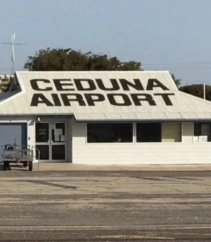 Sign on a building reading 'CEDUNA AIRPORT' in large black letters.