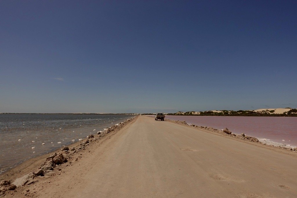 Lake MacDonald pink and blue lake on either side of a road