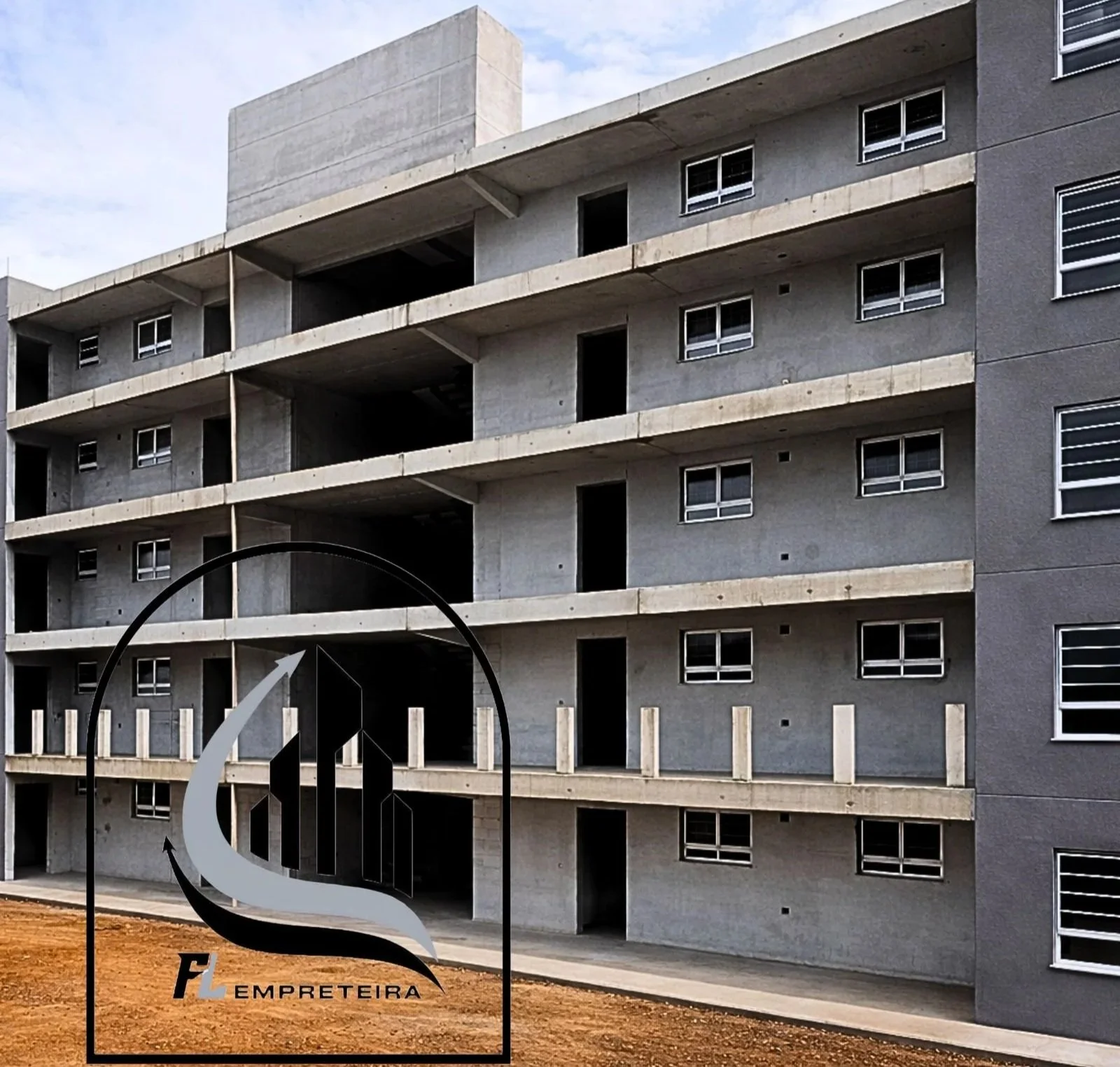 Edifício de vários andares em construção, com janelas e varandas, visto de frente, com sinal de loja de materiais de construção em primeiro plano.