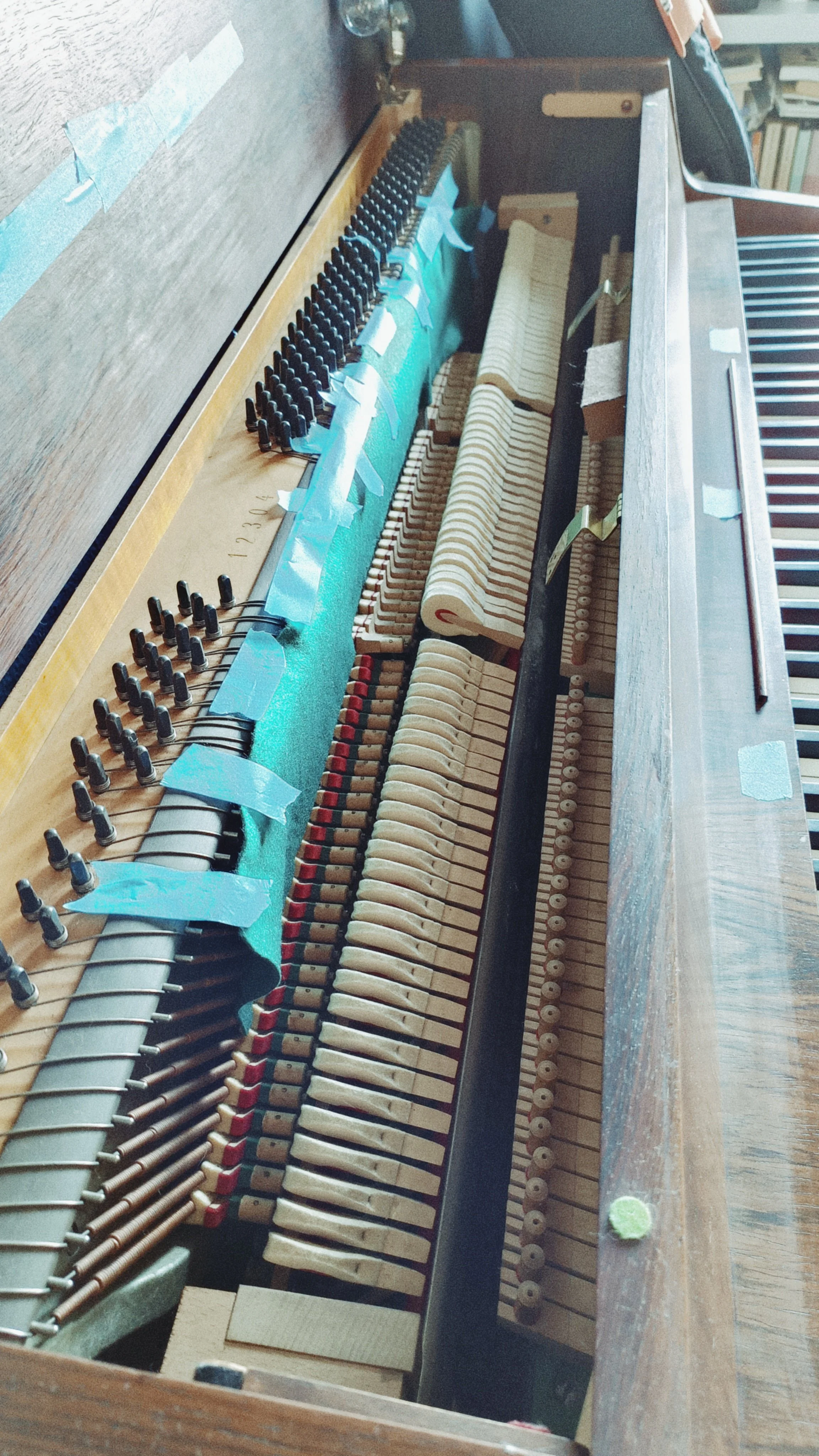 The inner mechanics of a piano, exposing the strings, hammers, and felt parts.
