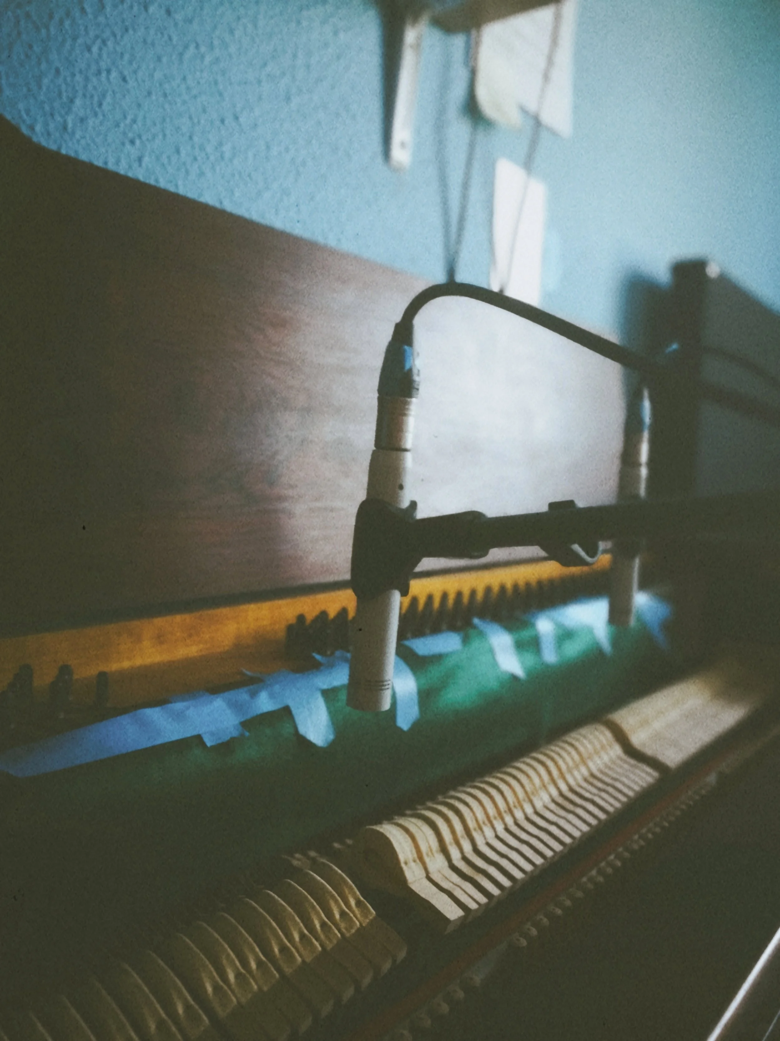 Close-up of a piano keyboard with black and white keys, with some wires and electronic parts visible near the top of the image.
