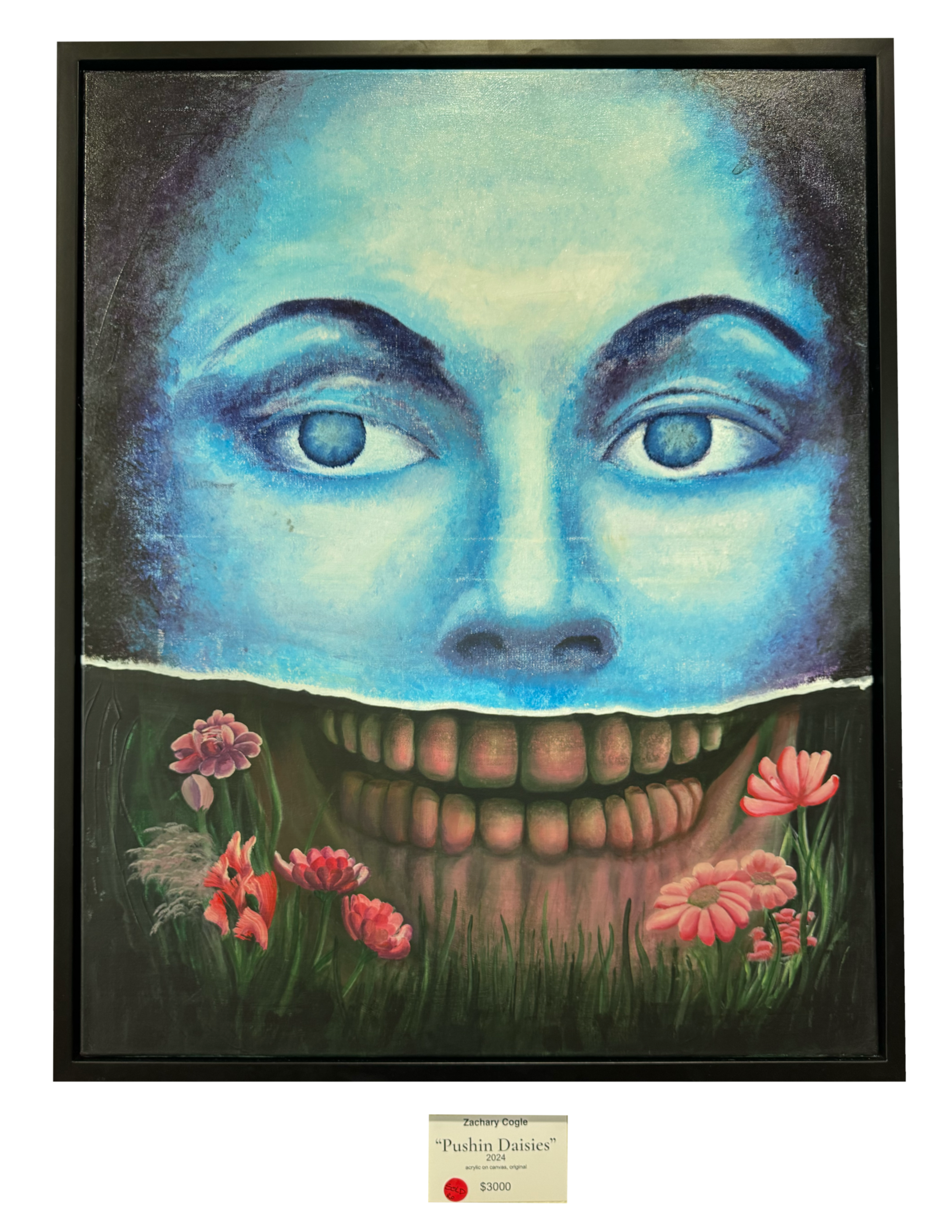 A framed painting titled 'Pushin Daisies' by Zachary Cogle, created in 2024, depicting a large surreal face with blue skin, human eyes, a big toothy grin, surrounded by pink daisies and green grass, with a small red sticker indicating a price of $3000.