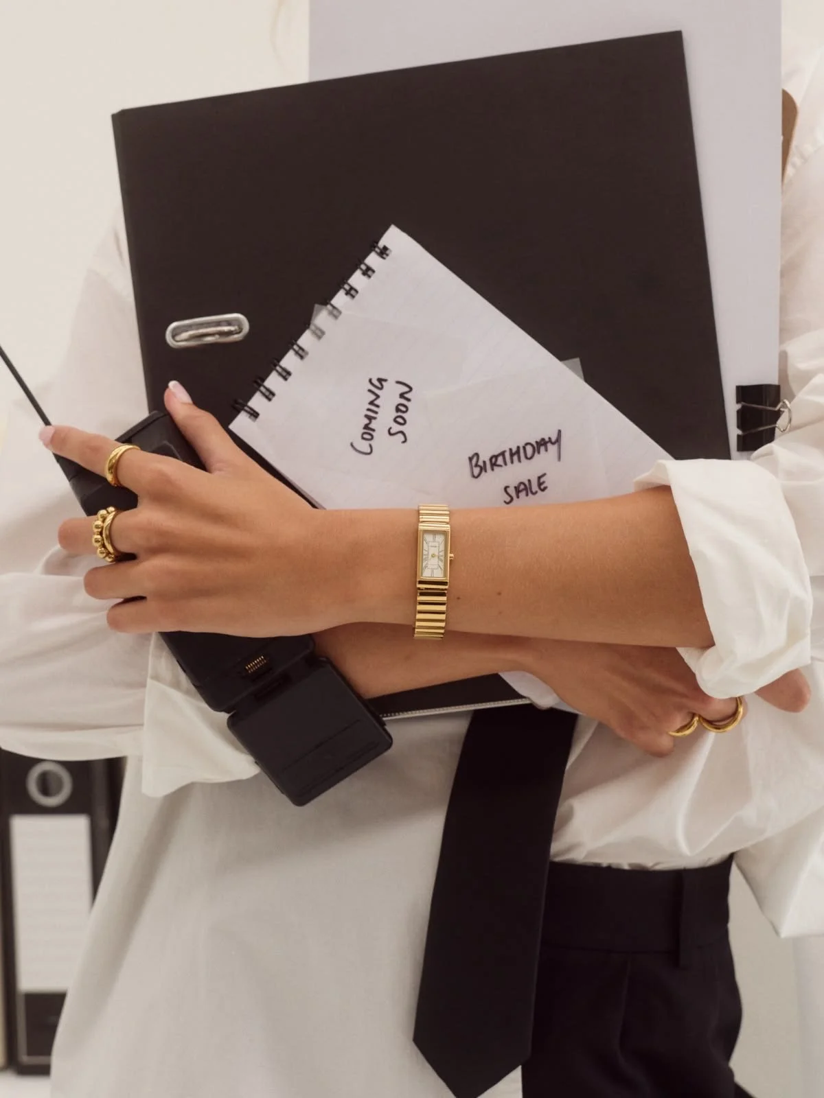 Sociél Muet Atelier Payroll Consultant holding a black planner, notepad, and cellphone ready to quietly create a payroll risk prevention plan with a CFO or HR Director