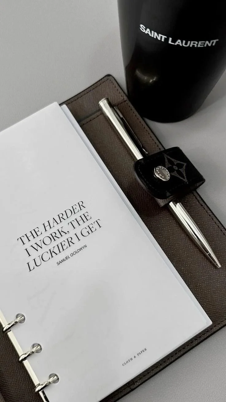 Sociél Muet Atelier Home Page - Black Payroll Planner opened to first page sitting next to a black Stanley cup with white words on it - Payroll Risk & Operations Consultant